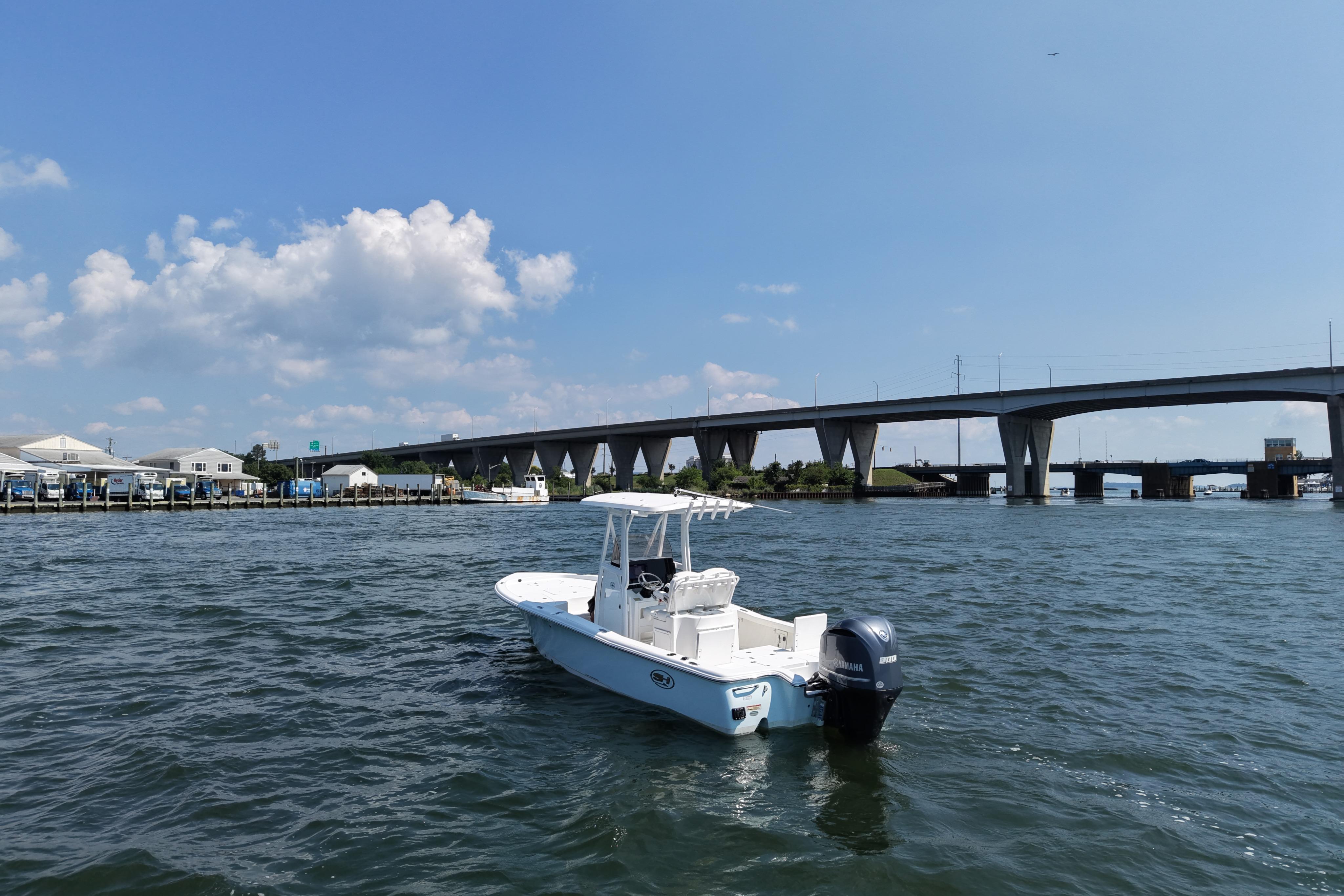 2017 Sea Hunt BX 25 BR boat on water near a bridge under a clear sky.