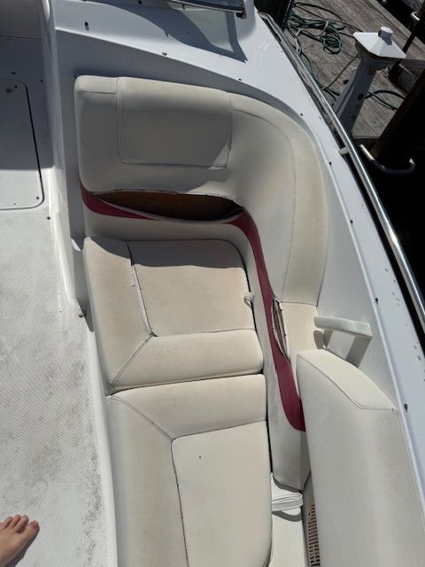 The boat's interior features white upholstery with red accents and a curved seating area.