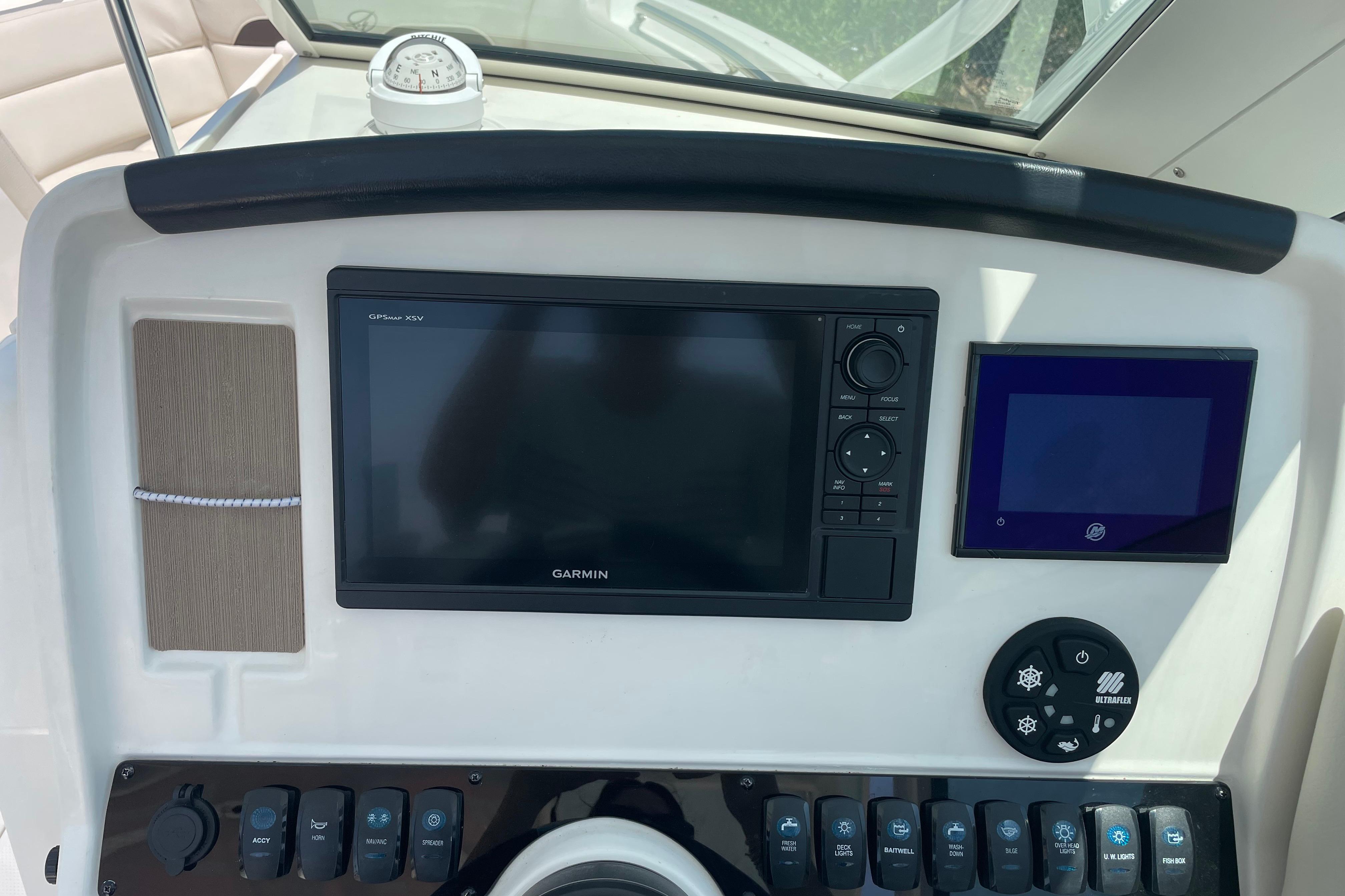 Dashboard of 2022 Sailfish 245 DC boat with Garmin GPS and controls.