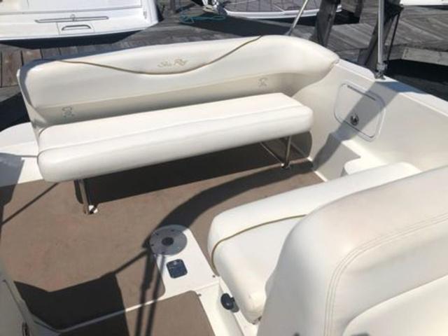 2003 Sea Ray 260 Sundancer boat interior with white seating and beige flooring.