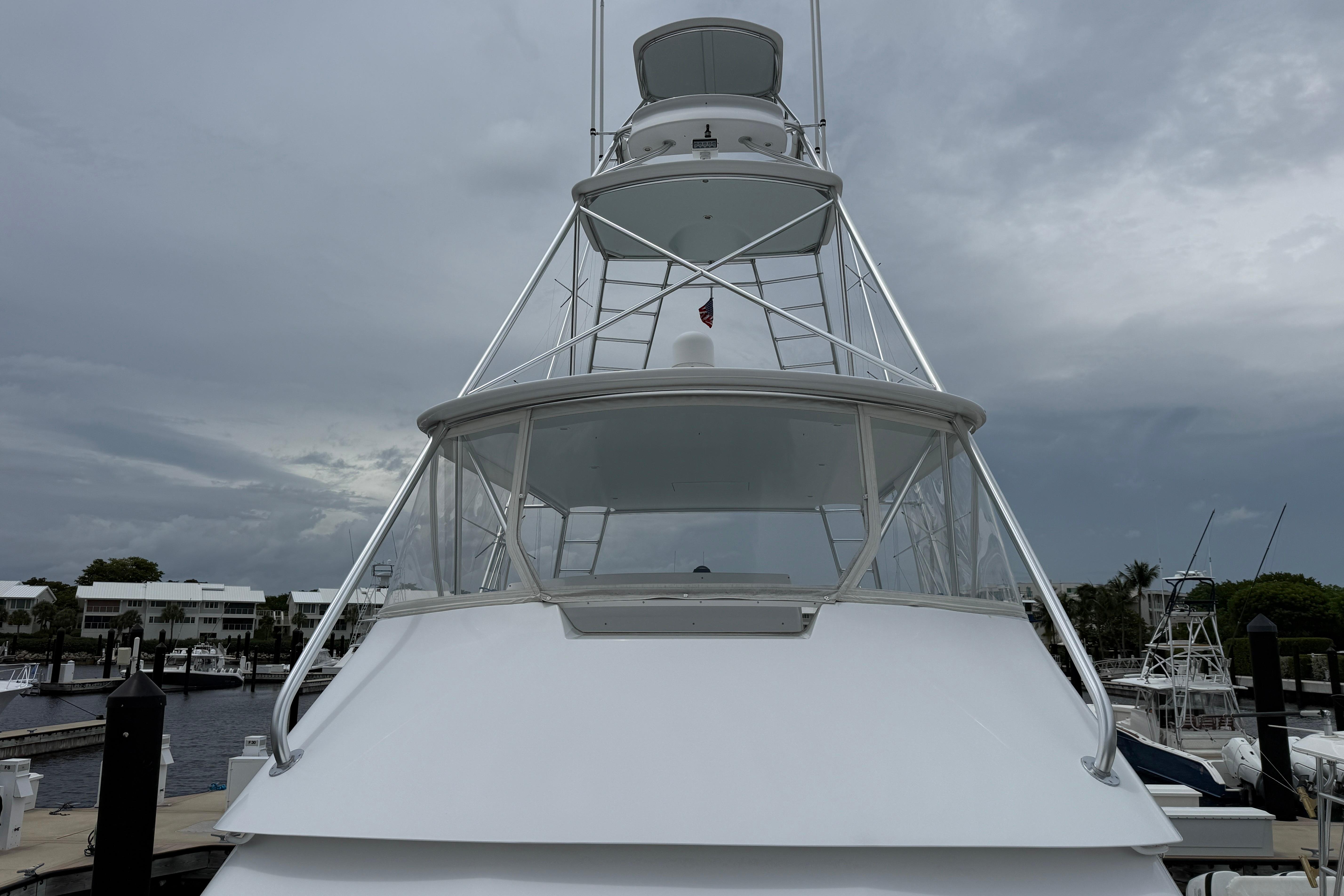 Viking 55 Convertible 2000 yacht docked under cloudy skies at a marina.