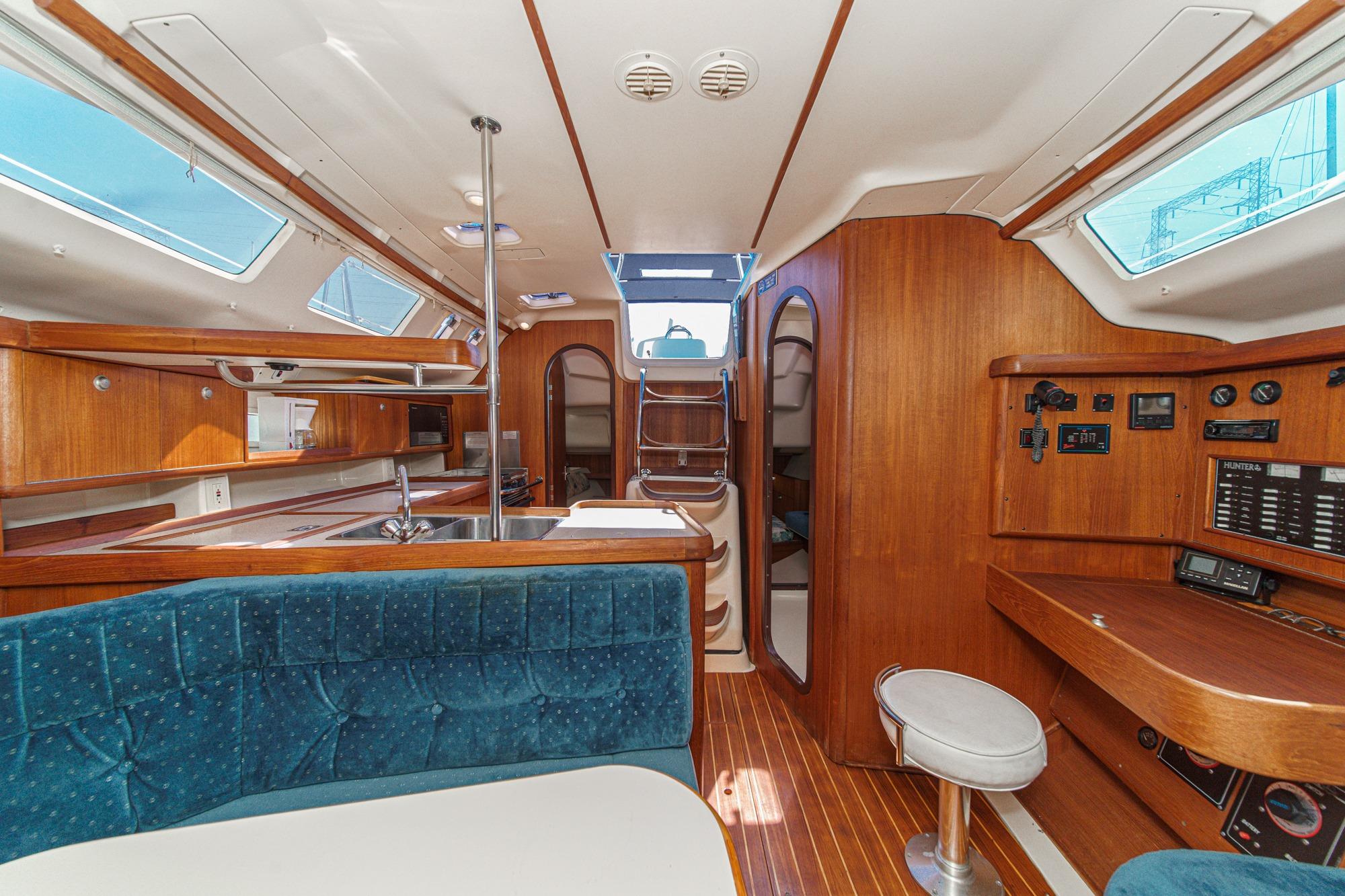 Interior of a 1996 Hunter 376 sailboat with wood finish and blue upholstery.