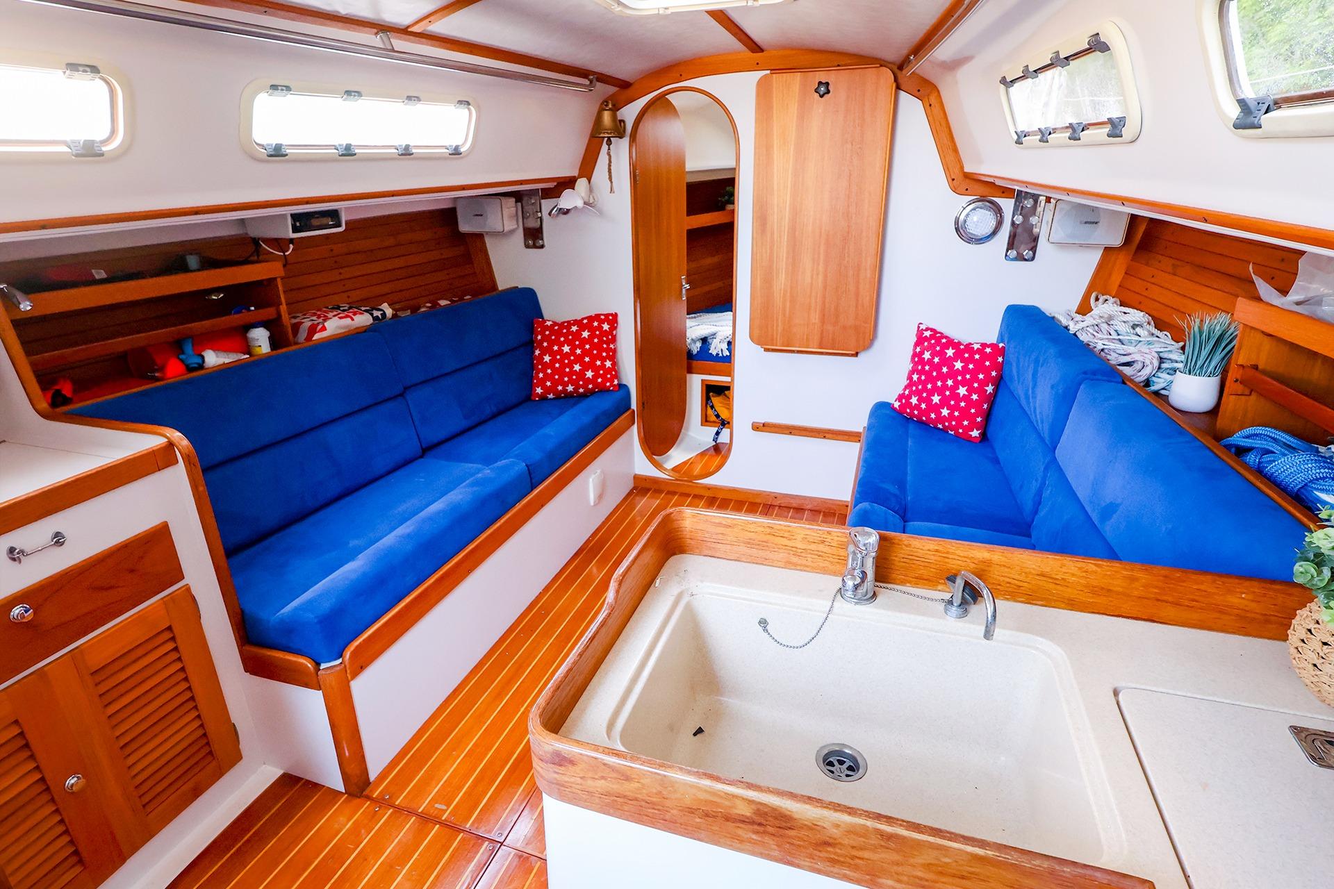 Interior of 2001 J Boats J/32 sailboat with blue seating and wooden accents.