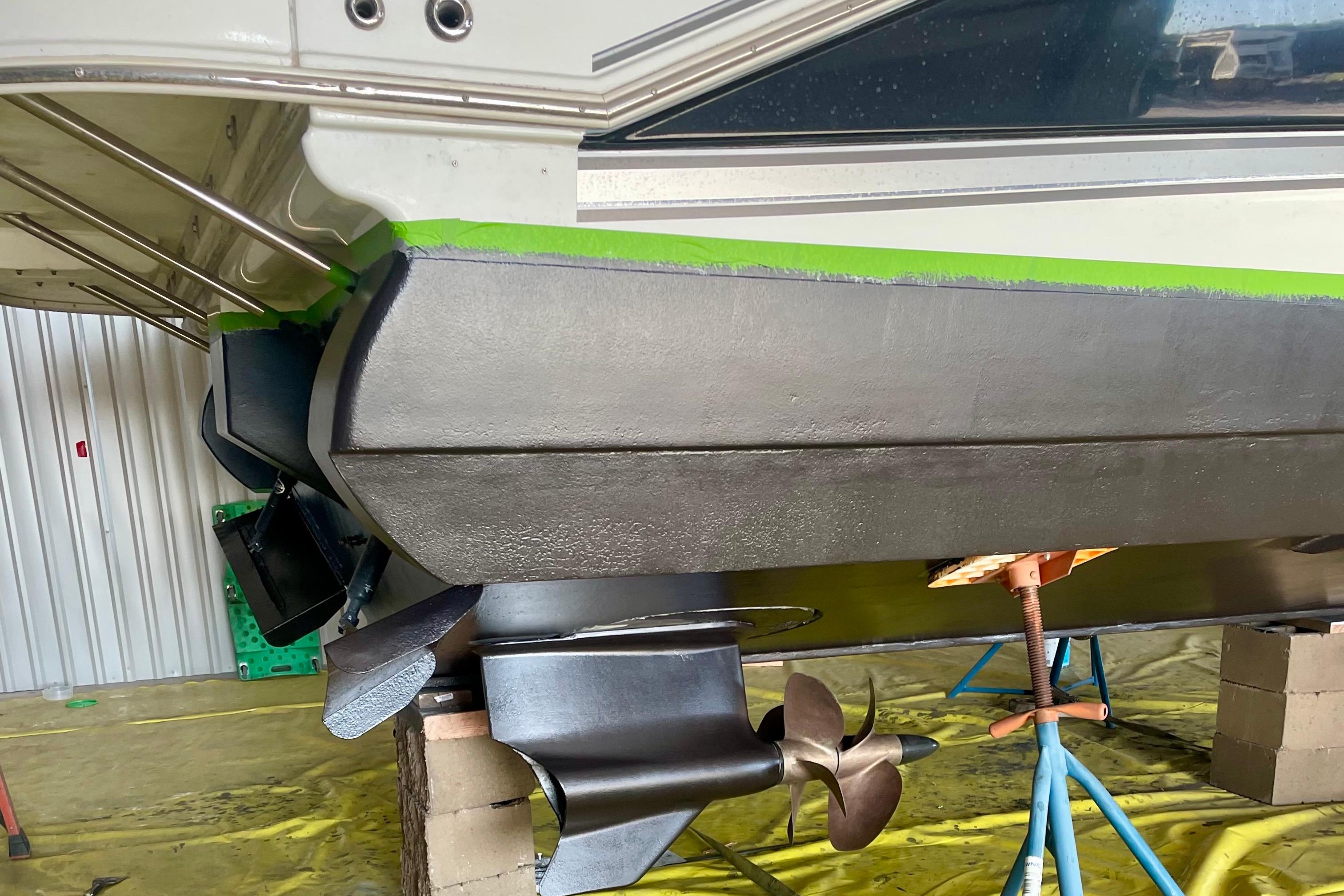 2011 Cruisers Yachts 390 Sports Coupe hull and propeller in maintenance setting.