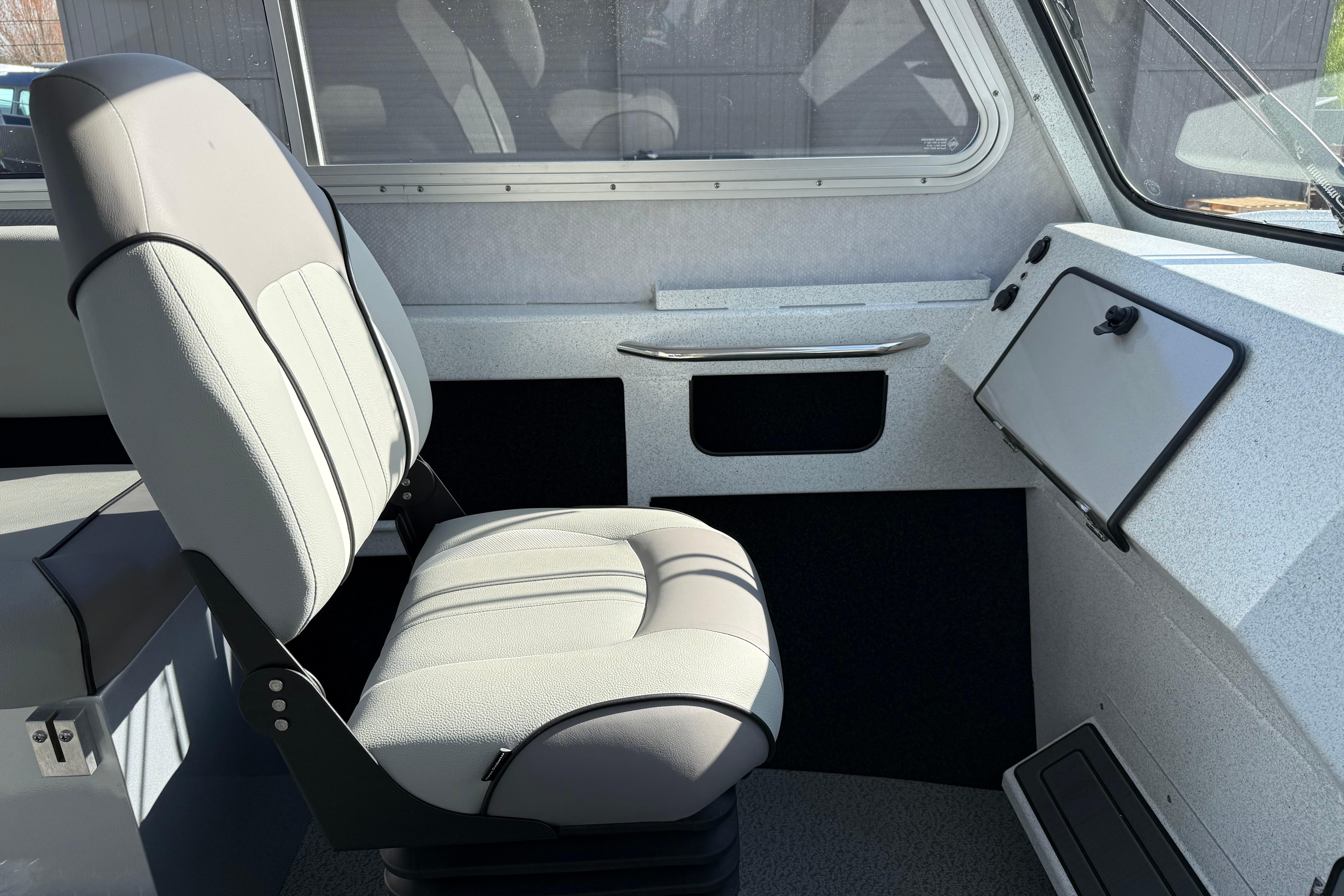 Interior of 2026 KingFisher 2425 Escape HT boat, featuring a comfortable captain's chair.
