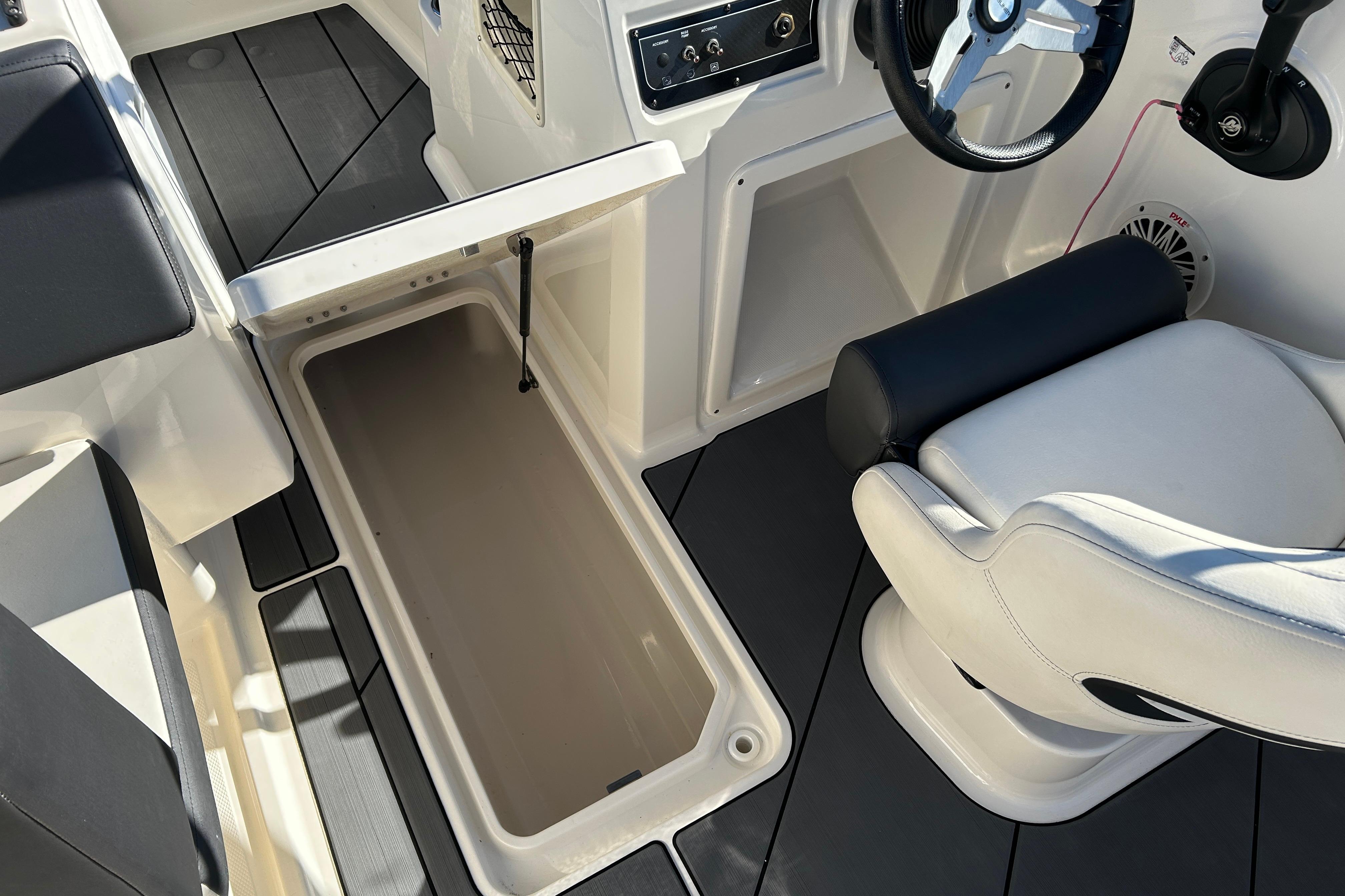 Interior of 2020 Bayliner DX 2000 boat showing storage compartment and seating.