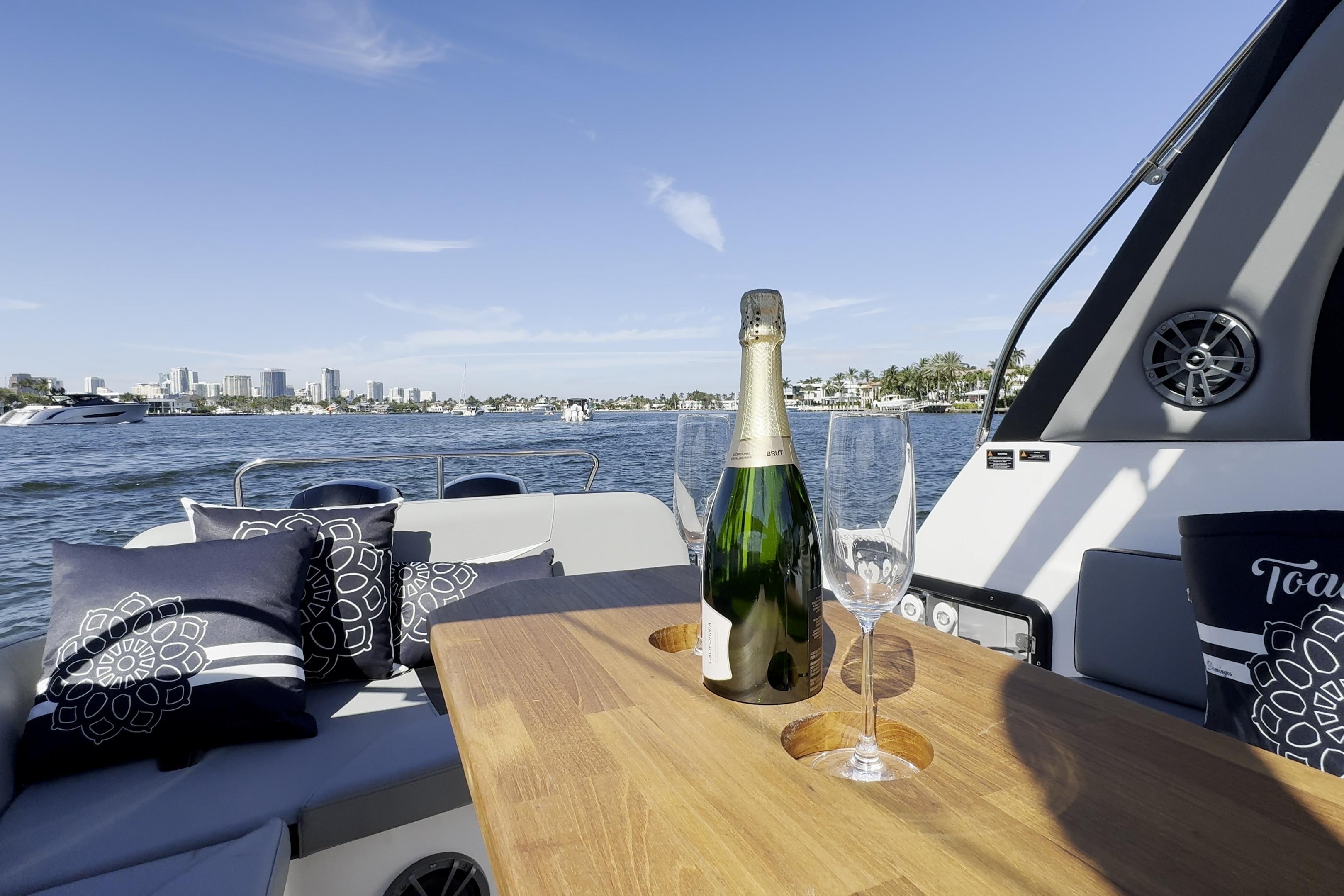 Luxurious Hanover 305 boat interior with champagne and glasses, city skyline in the background, 2027 model.