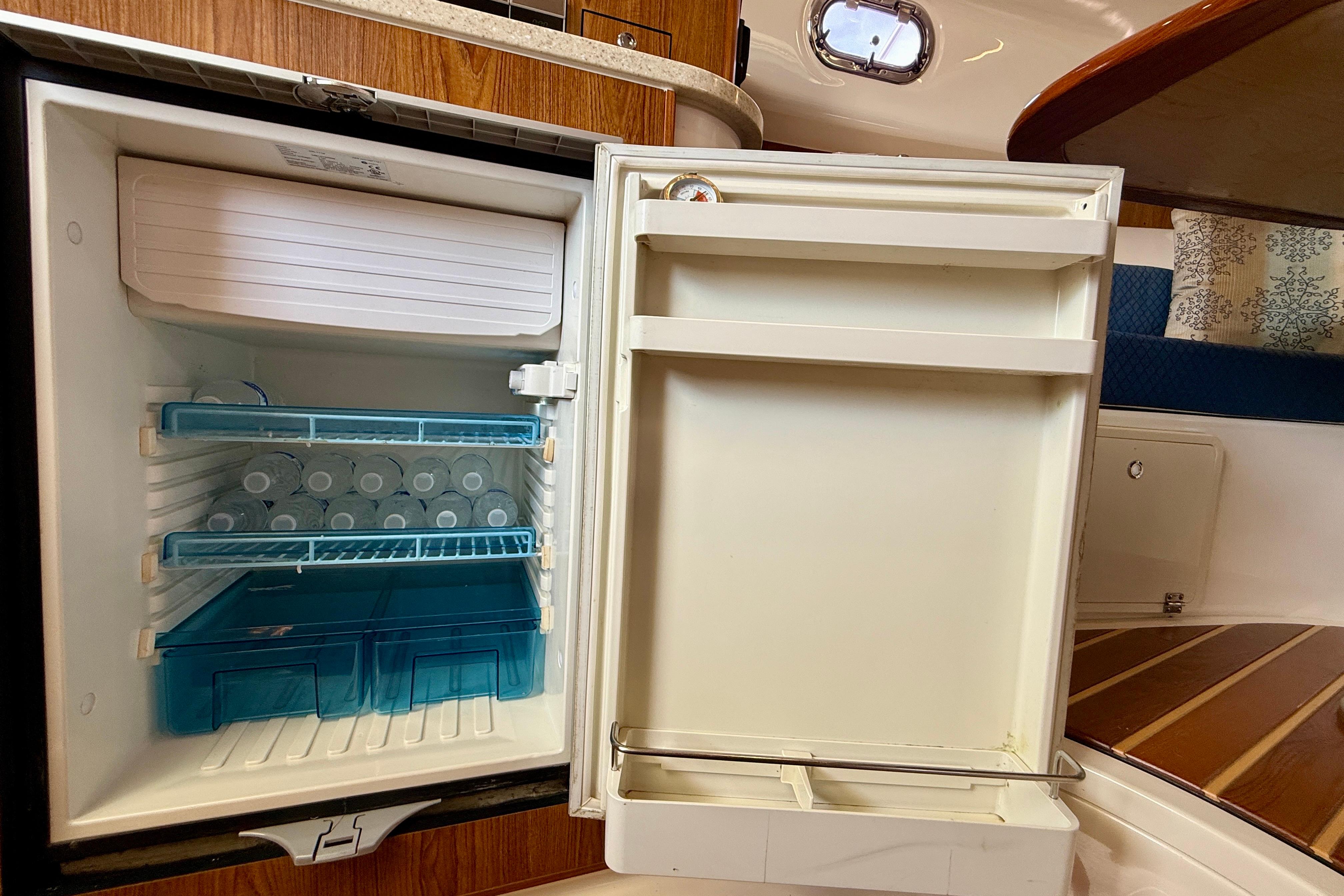 Refrigerator inside 2012 Pursuit OS 345 Offshore boat, stocked with water bottles.