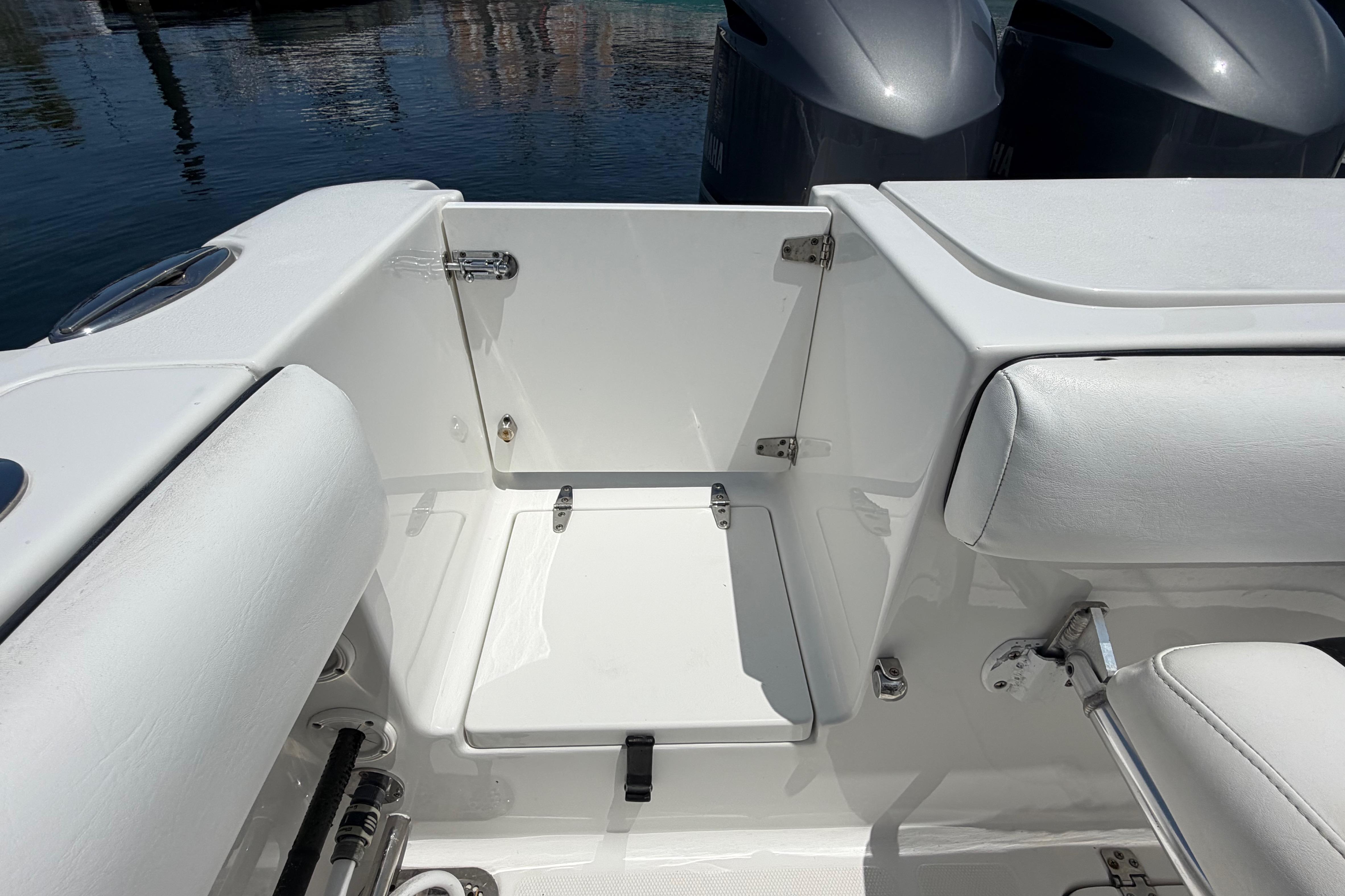 2019 Sea Hunt Gamefish 27 Coffin Box interior, featuring sleek white seating and storage.