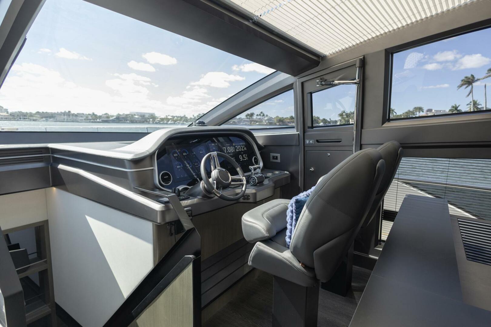 Luxurious 2023 Pearl 72 yacht cockpit with modern steering and panoramic windows.