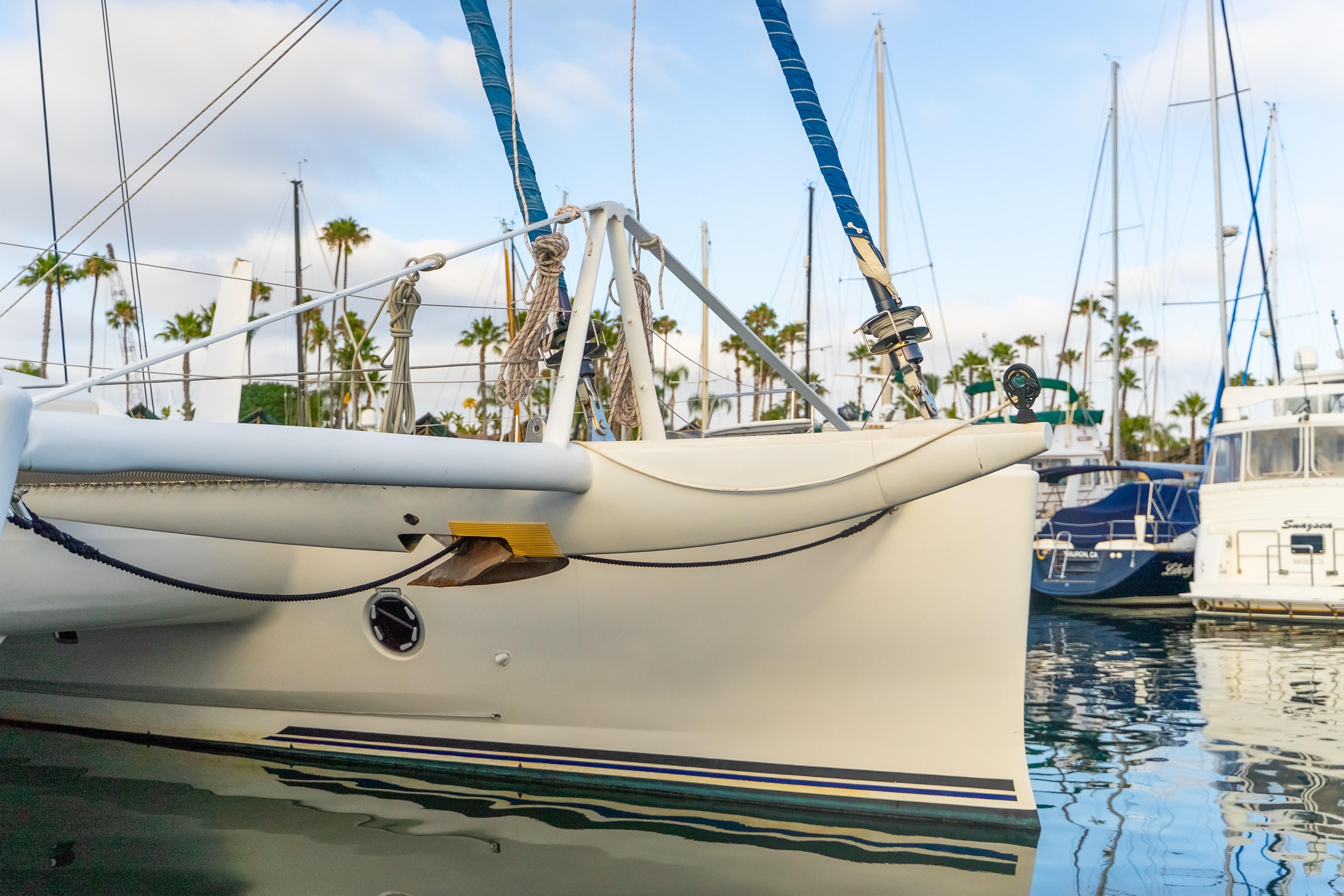 Catana 65 catamaran from 2009 docked in a marina with palm trees.