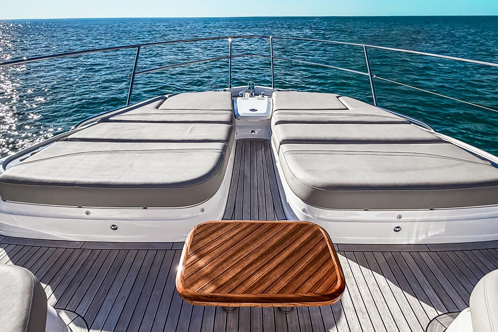 Luxurious 2026 Princess S65 Sportbridge yacht deck with sun loungers and ocean view.
