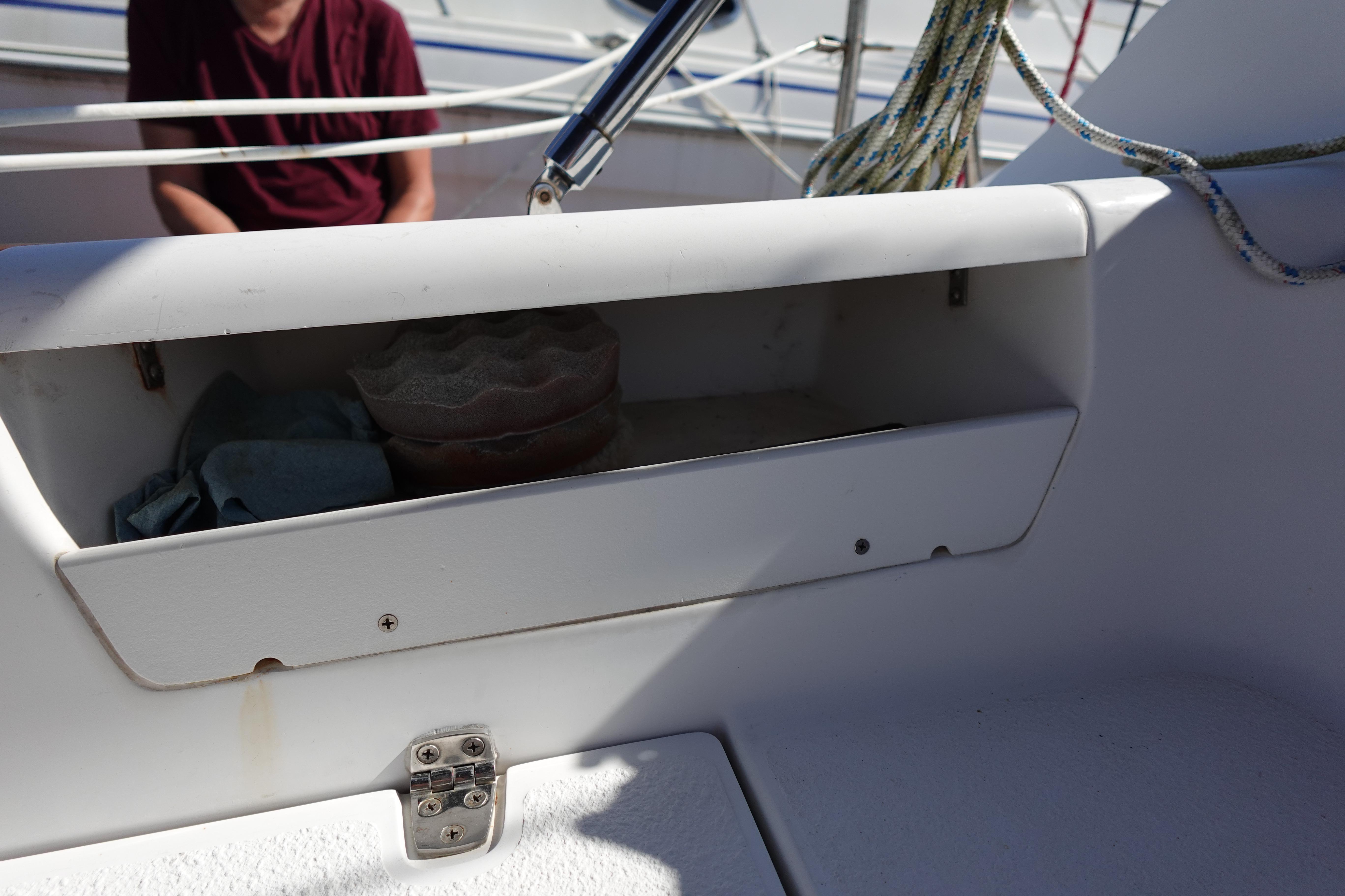 Open storage compartment on 1997 Catalina 28 sailboat with ropes and items inside.