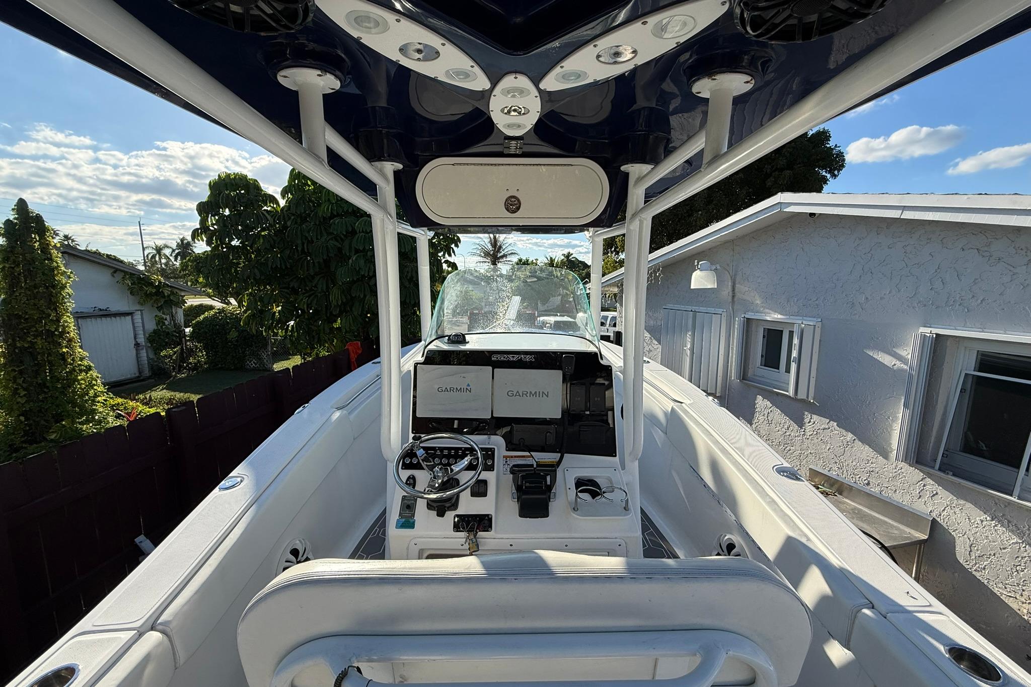 2014 Sea Fox 256 Commander boat interior with Garmin navigation system, parked near a house.