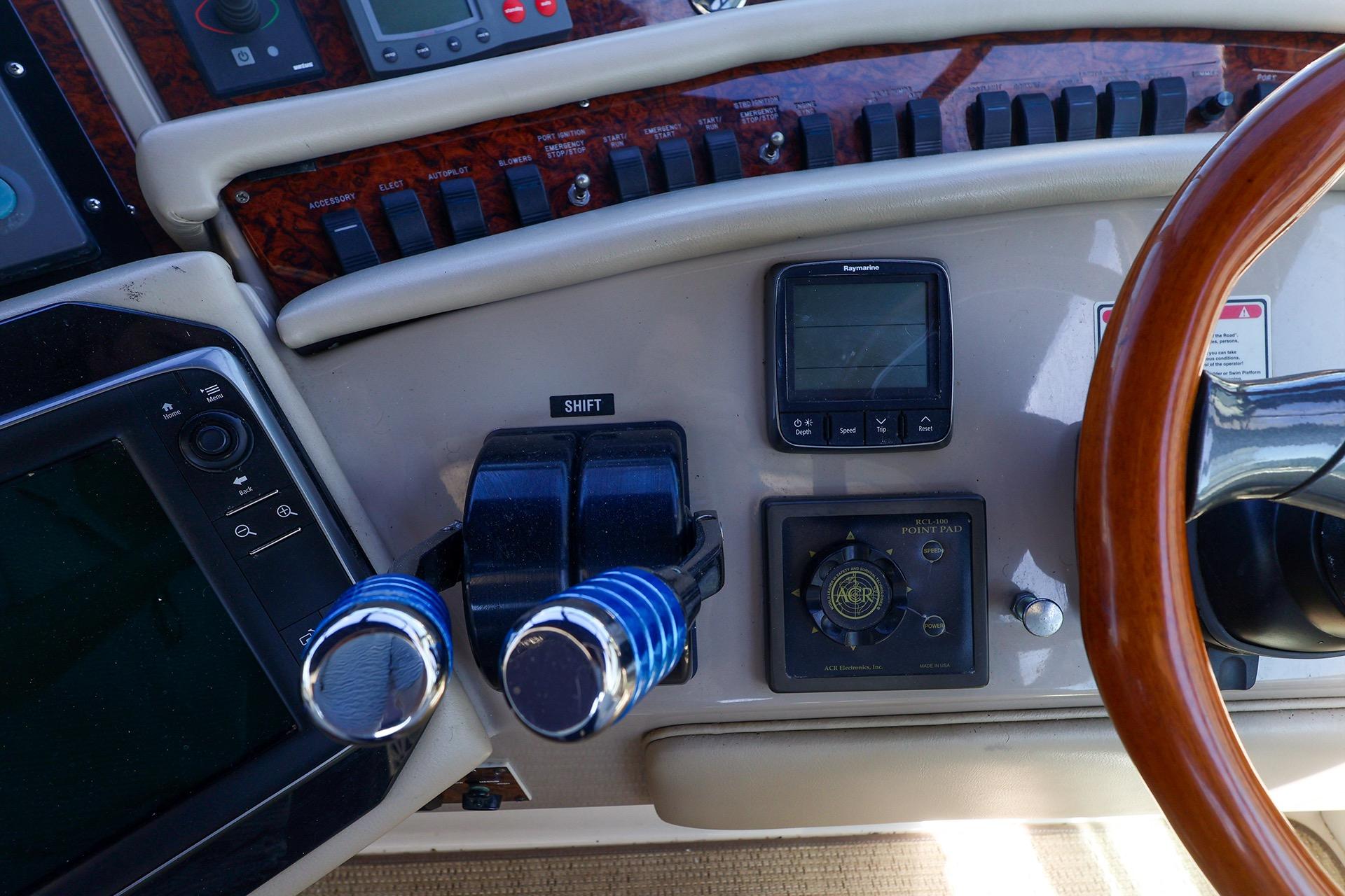 Control panel of a 1998 Sea Ray 500 Sundancer yacht with steering wheel and navigation instruments.