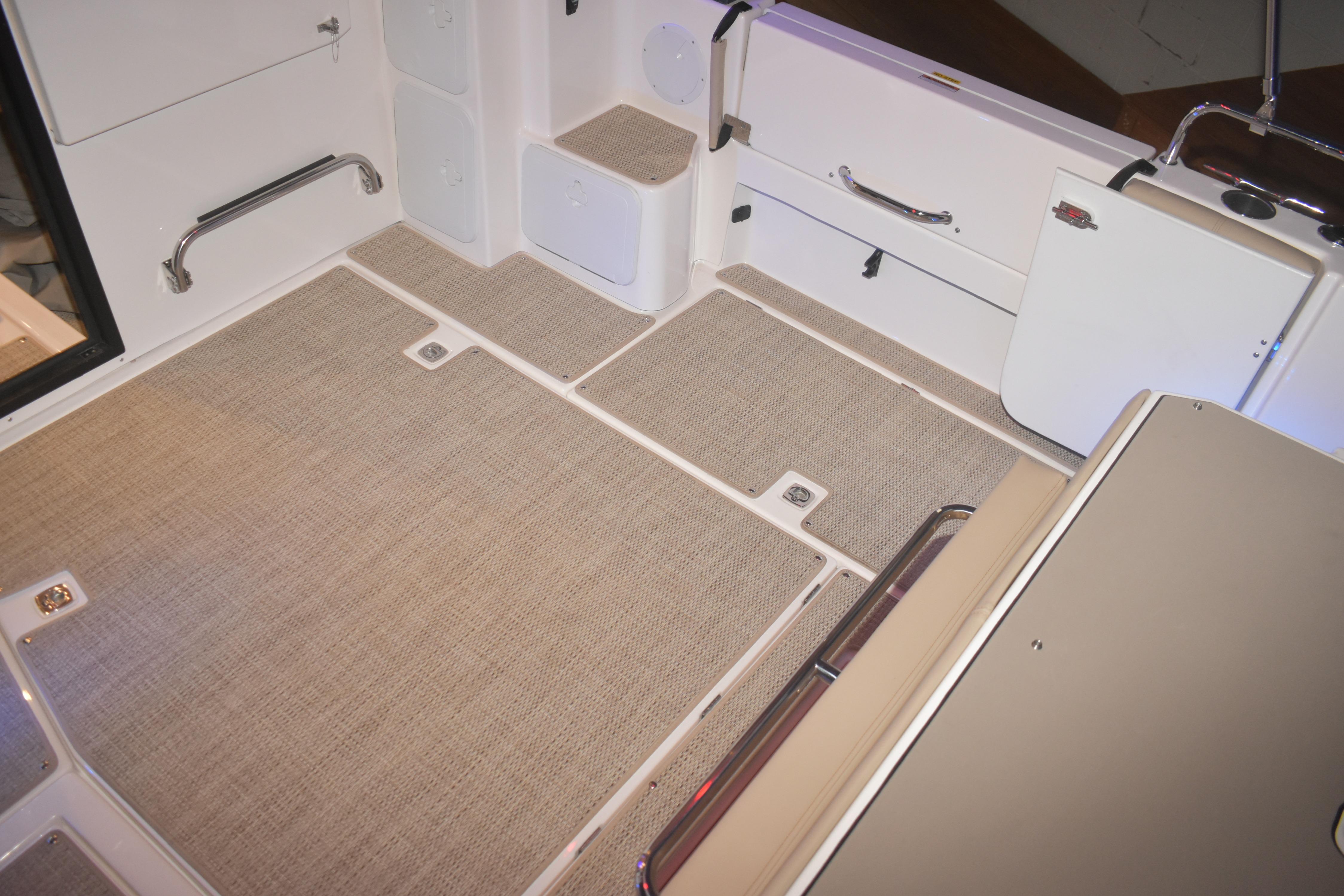 2026 Cutwater C-32 CB boat interior with beige flooring and storage compartments.