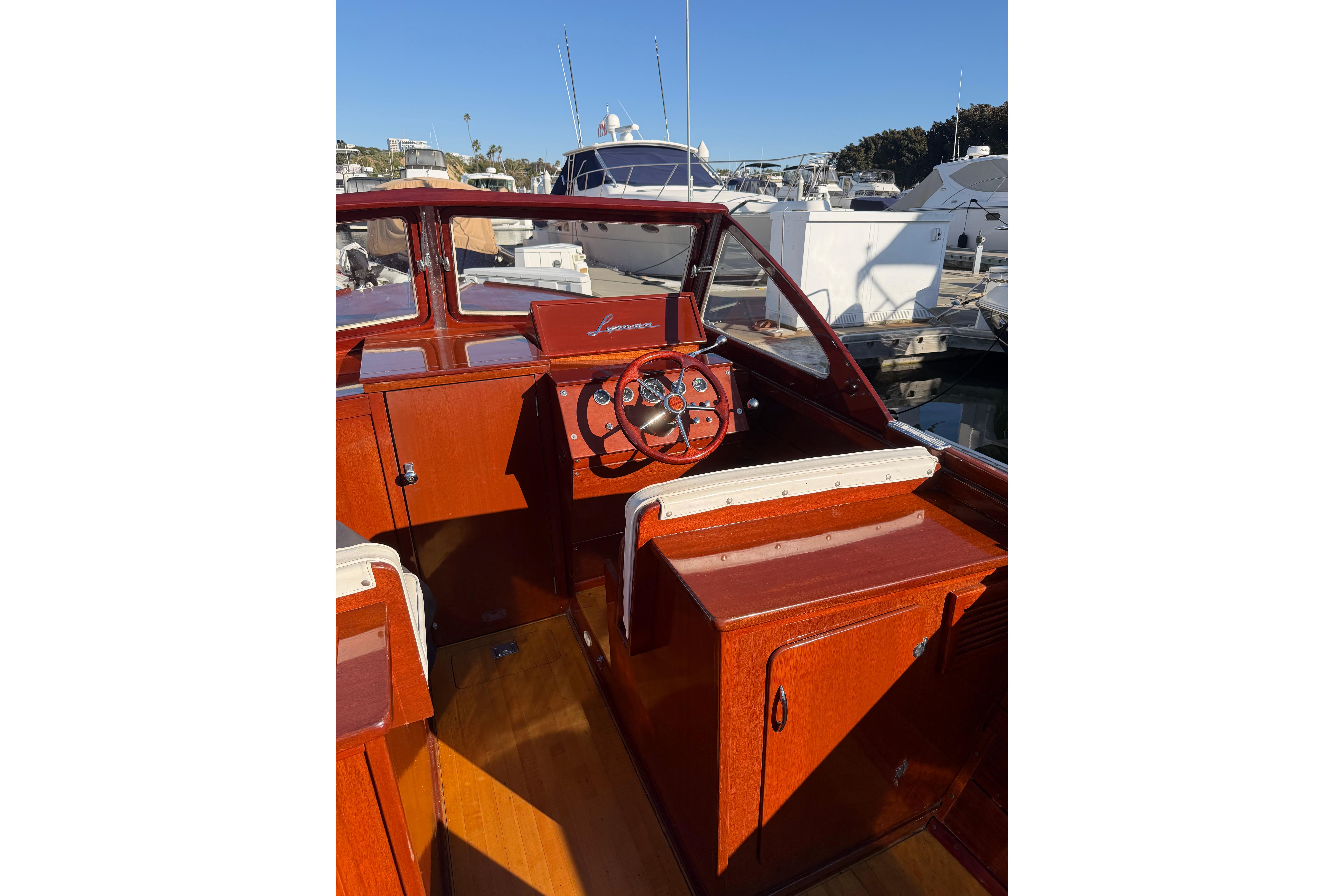 1964 Lyman 25 Sleeper boat interior with wooden dashboard and steering wheel.