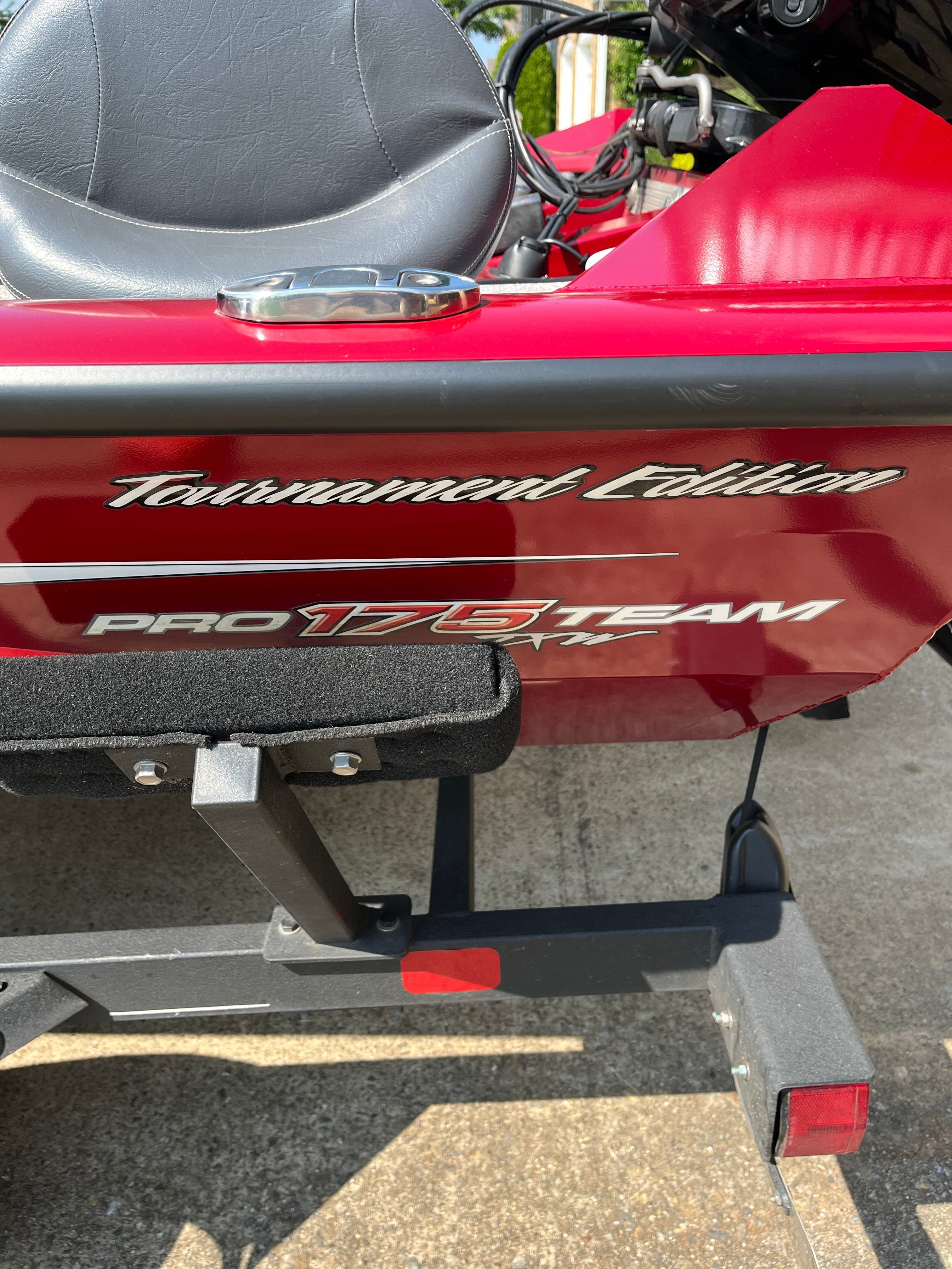 Close-up of a red Bass Tracker PRO 175 TEAM TXW Tournament Edition boat on a trailer.