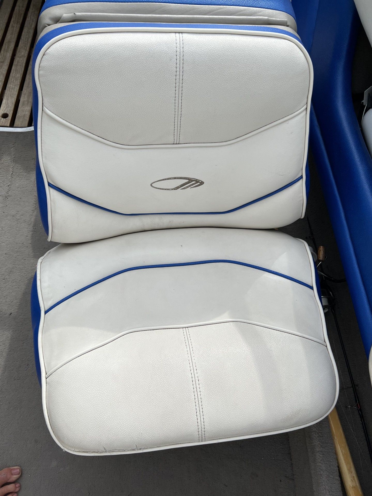 Two white boat seats with blue accents and an embroidered logo.