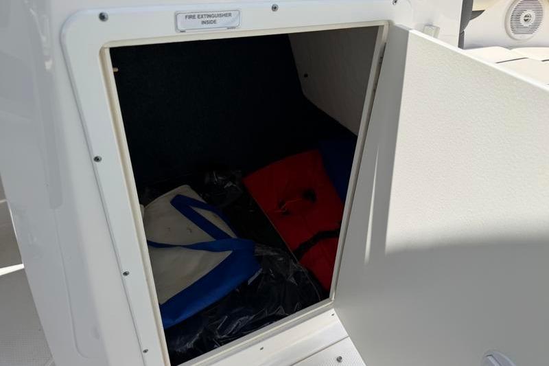 Storage compartment on a 2017 Yamaha SX210 boat, containing life jackets and safety equipment.