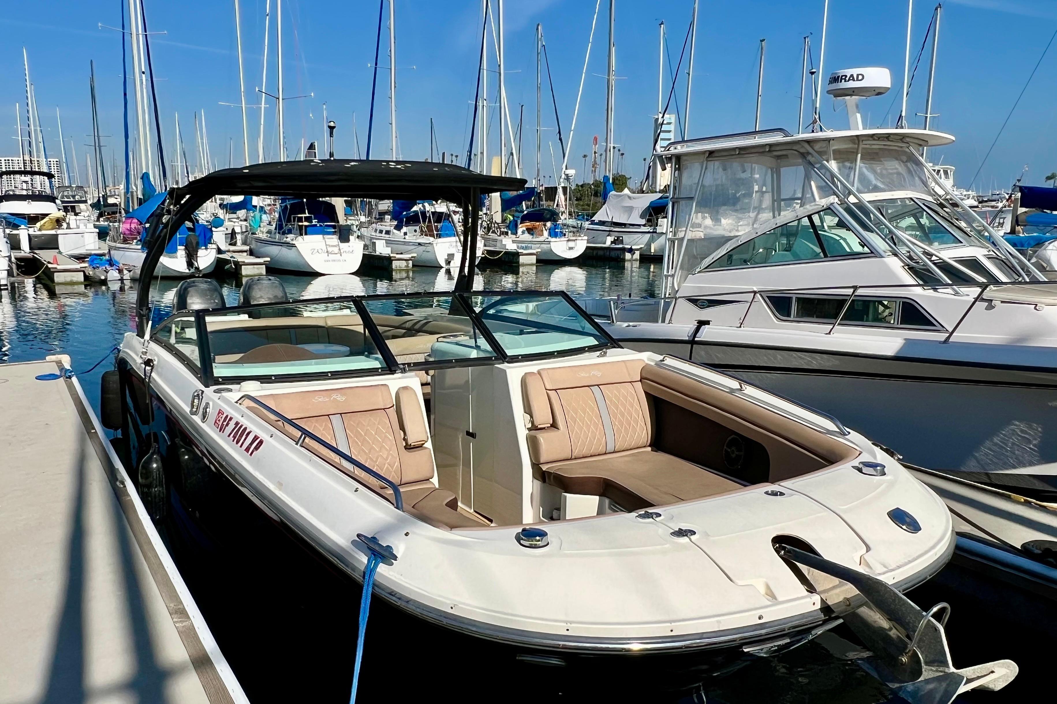 2016 Sea Ray 290 Sundeck Outboard docked at marina with sailboats in background.