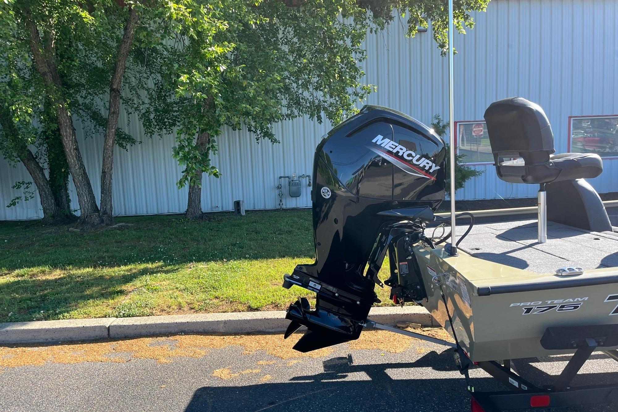 2026 Tracker Pro Team 175 boat with Mercury engine, parked outdoors near trees.