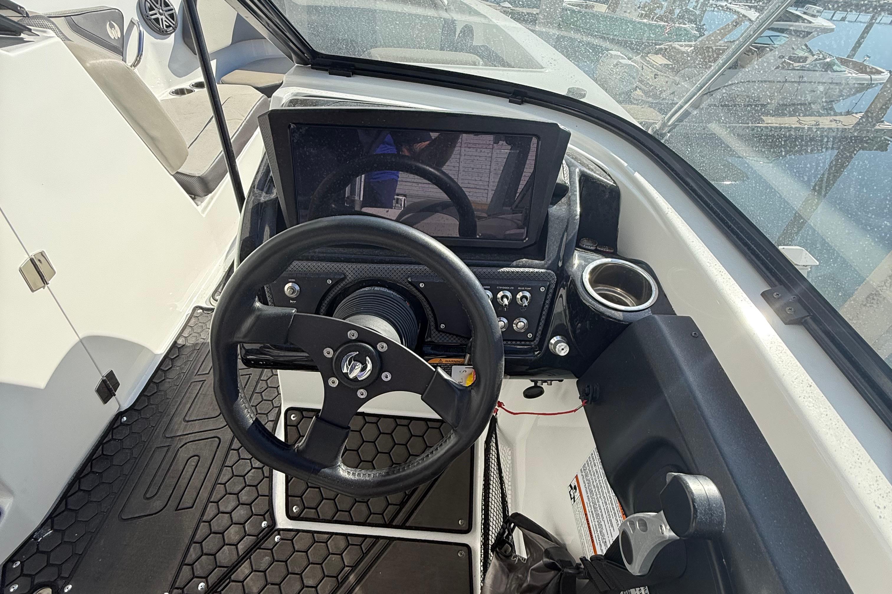 2021 Scarab 255 ID boat dashboard with steering wheel and control panel.