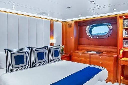 Luxurious cabin interior of 2004 Perini Navi 56m yacht with elegant wood finishes and porthole view.