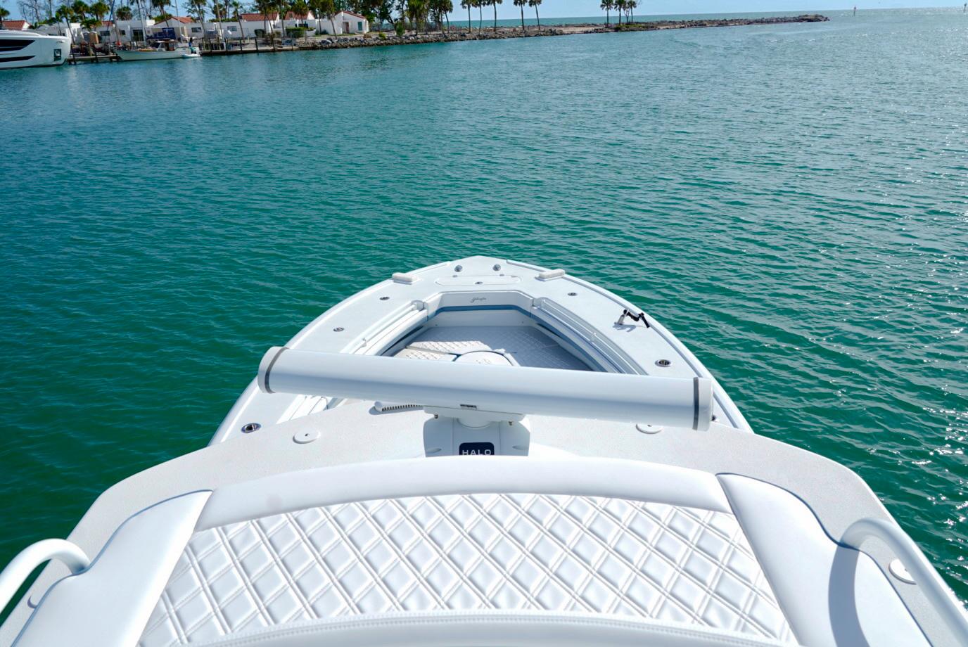 2023 Yellowfin 42 boat on calm turquoise water near a marina.