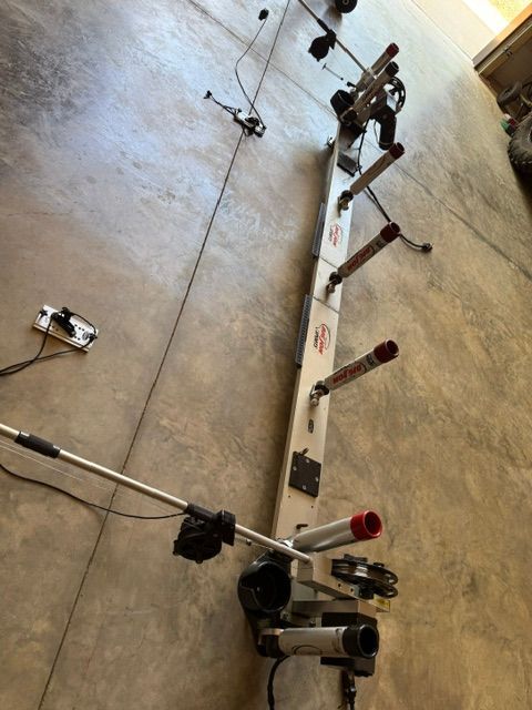 A fishing rod holder with multiple mounts is laid out on a concrete floor.