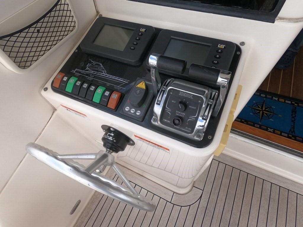 Control panel of a 2003 Riviera 58 Convertible yacht with steering wheel and navigation instruments.