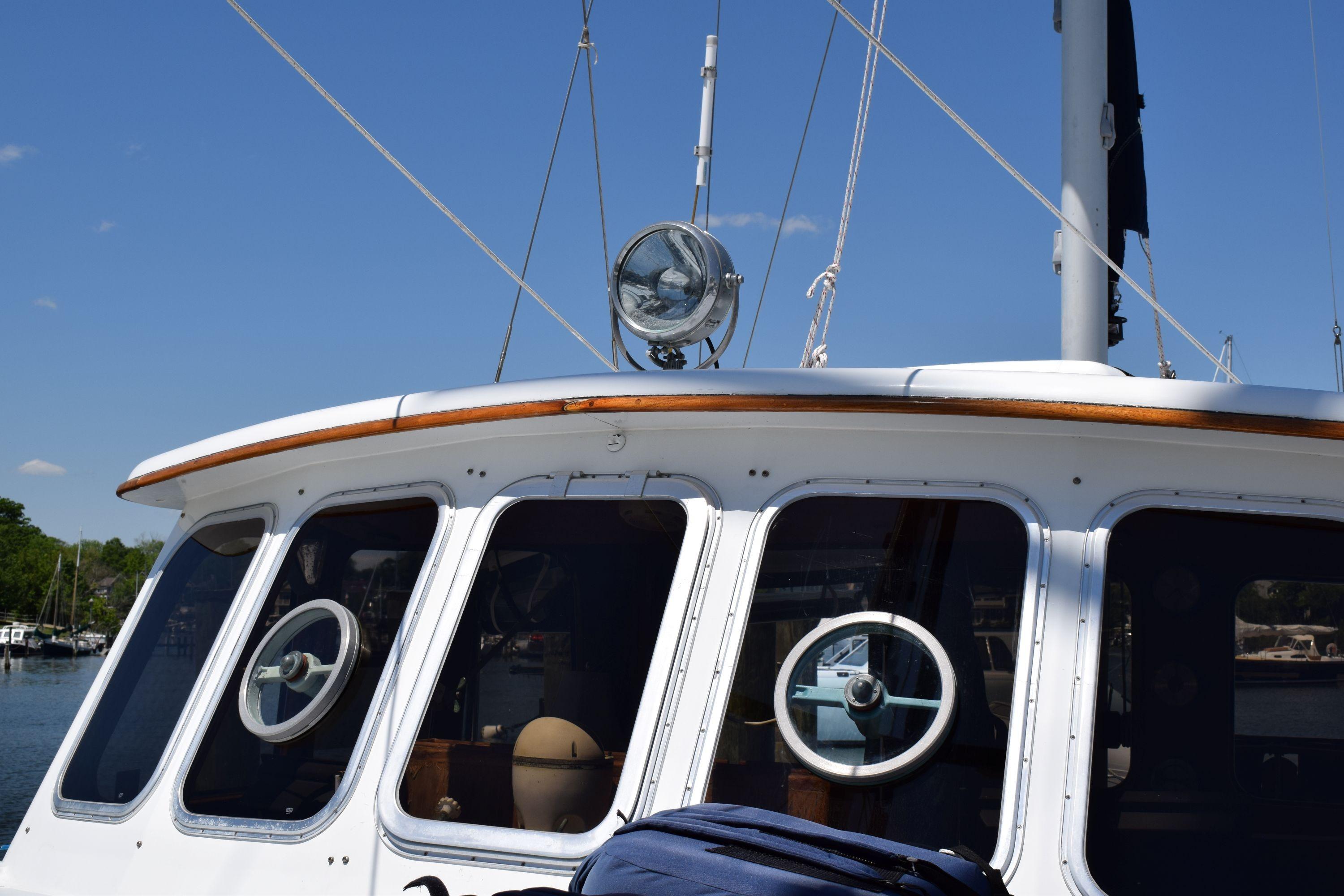 1980 Cheoy Lee 52 Motorsailer with portholes and deck details under clear sky.