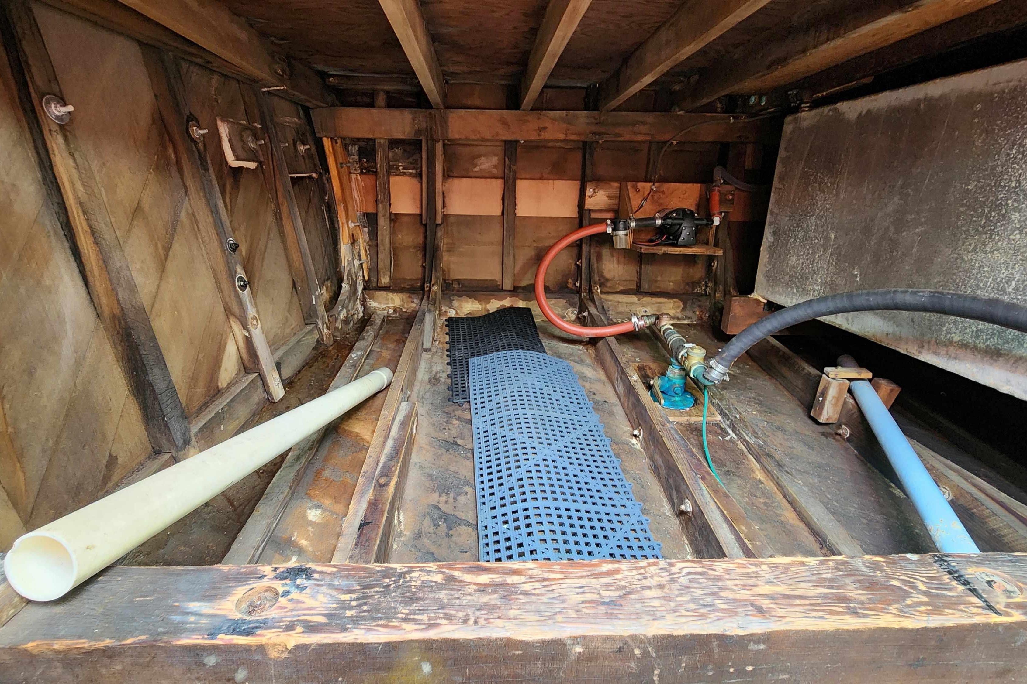 Interior view of a 1964 Grandy Tour Boat showing wooden structure and plumbing components.