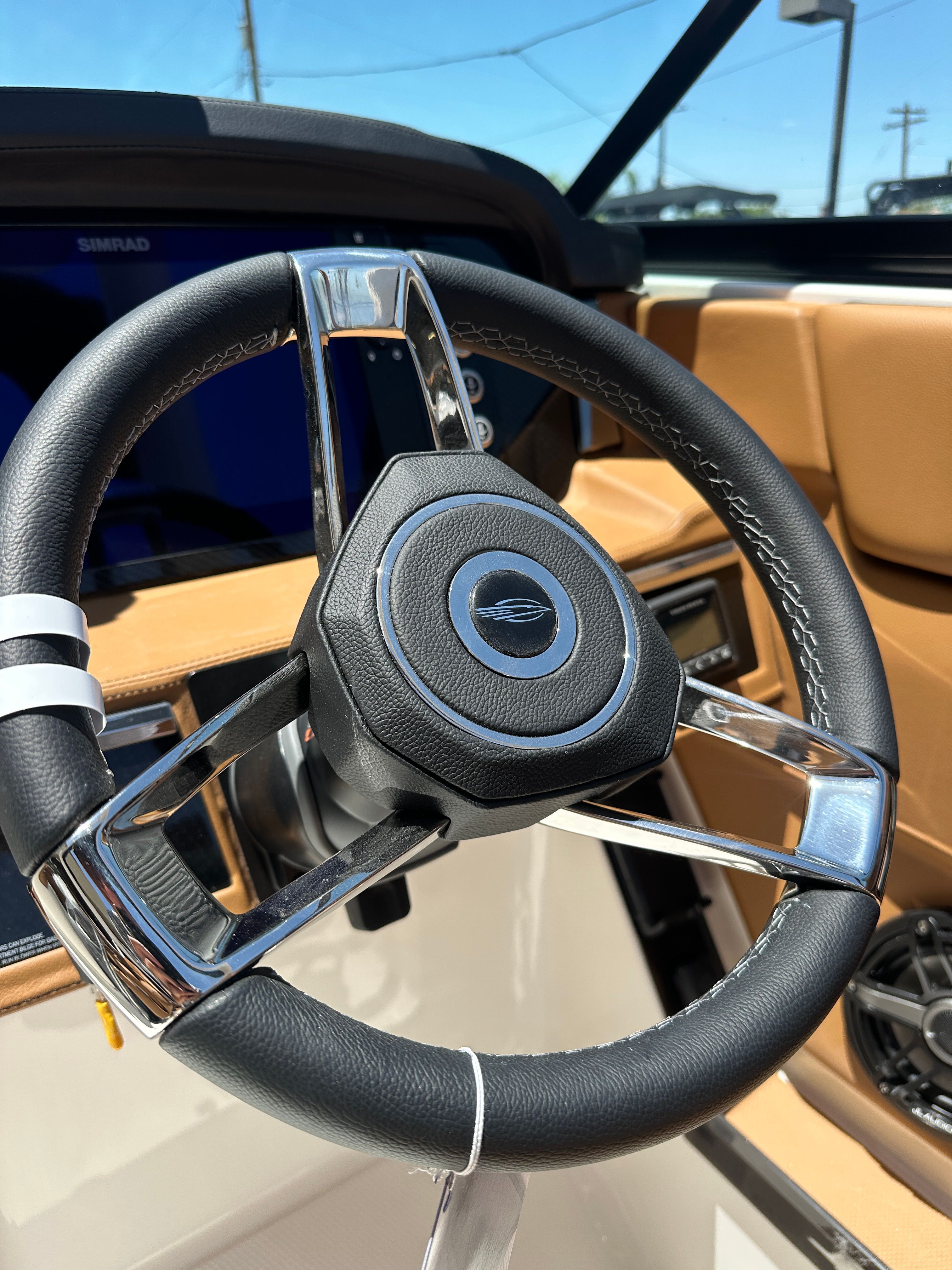 Steering wheel of a 2025 Chaparral 26 Surf with modern design and leather accents.
