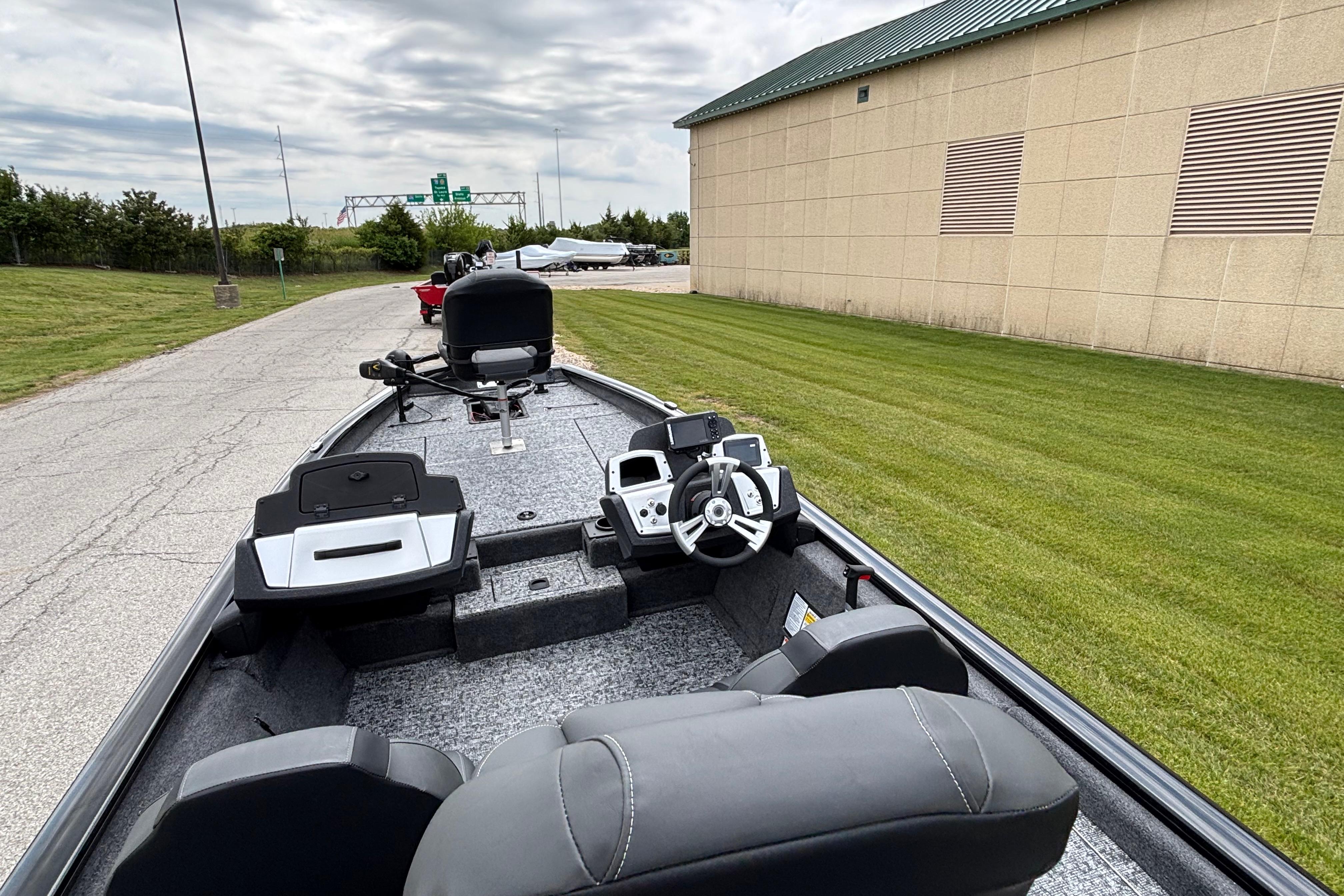 2026 Tracker Pro Team 190 boat interior with steering wheel and seating, parked outdoors.