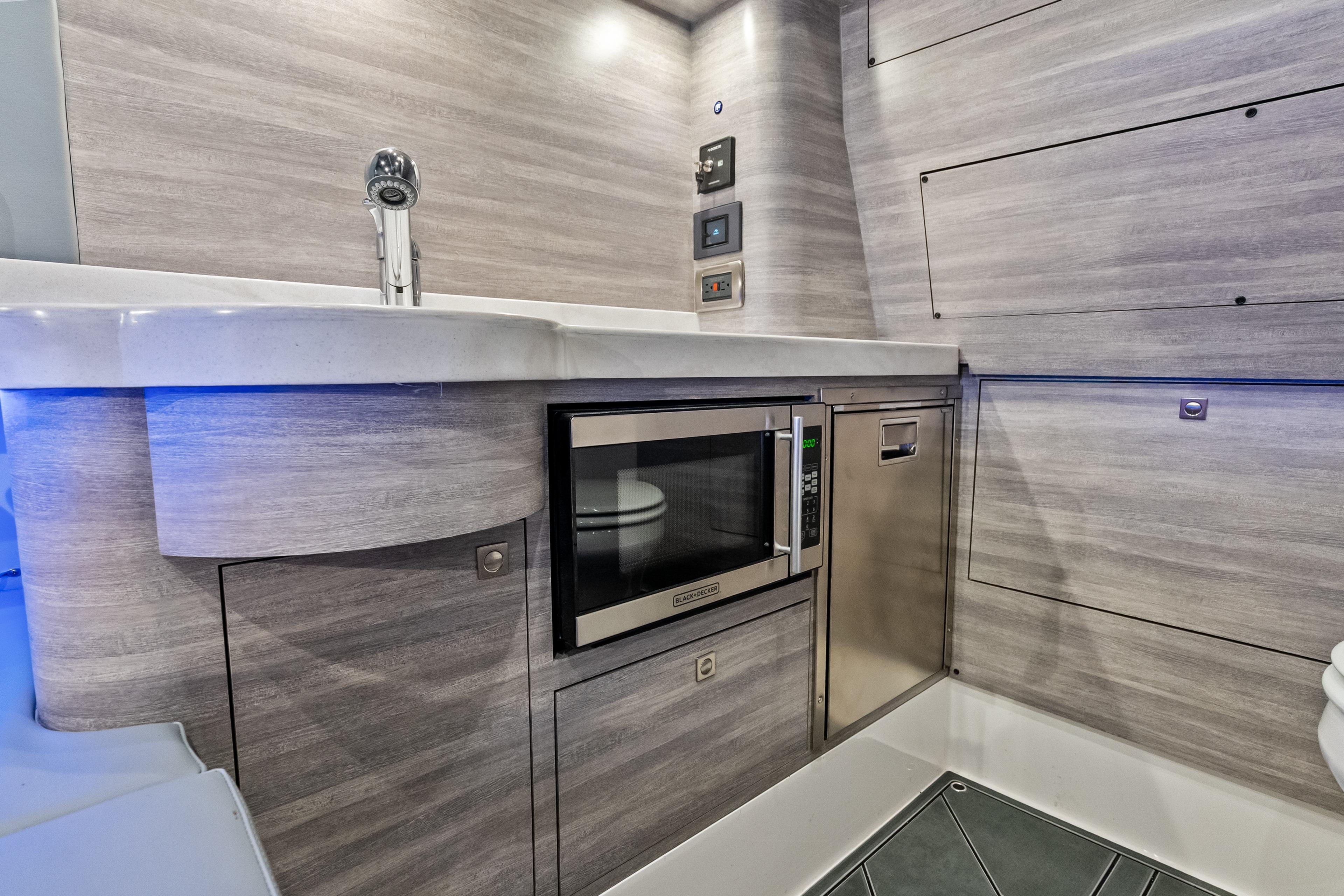 Modern kitchen area in 2027 Mystic Powerboats M4200, featuring sleek cabinetry and appliances.