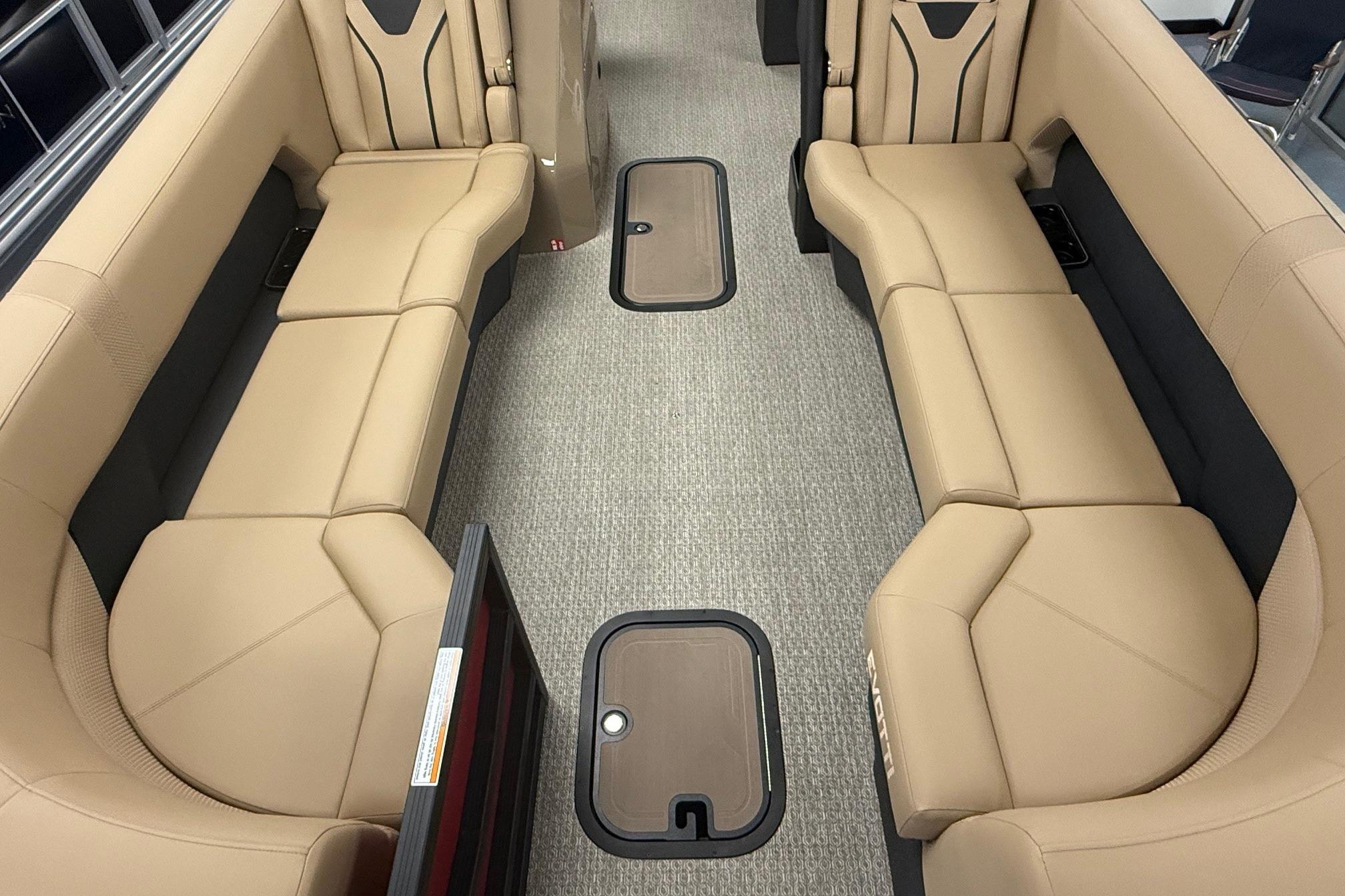 Luxurious interior of 2026 Evotti 725CS boat with beige seating and carpeted flooring.