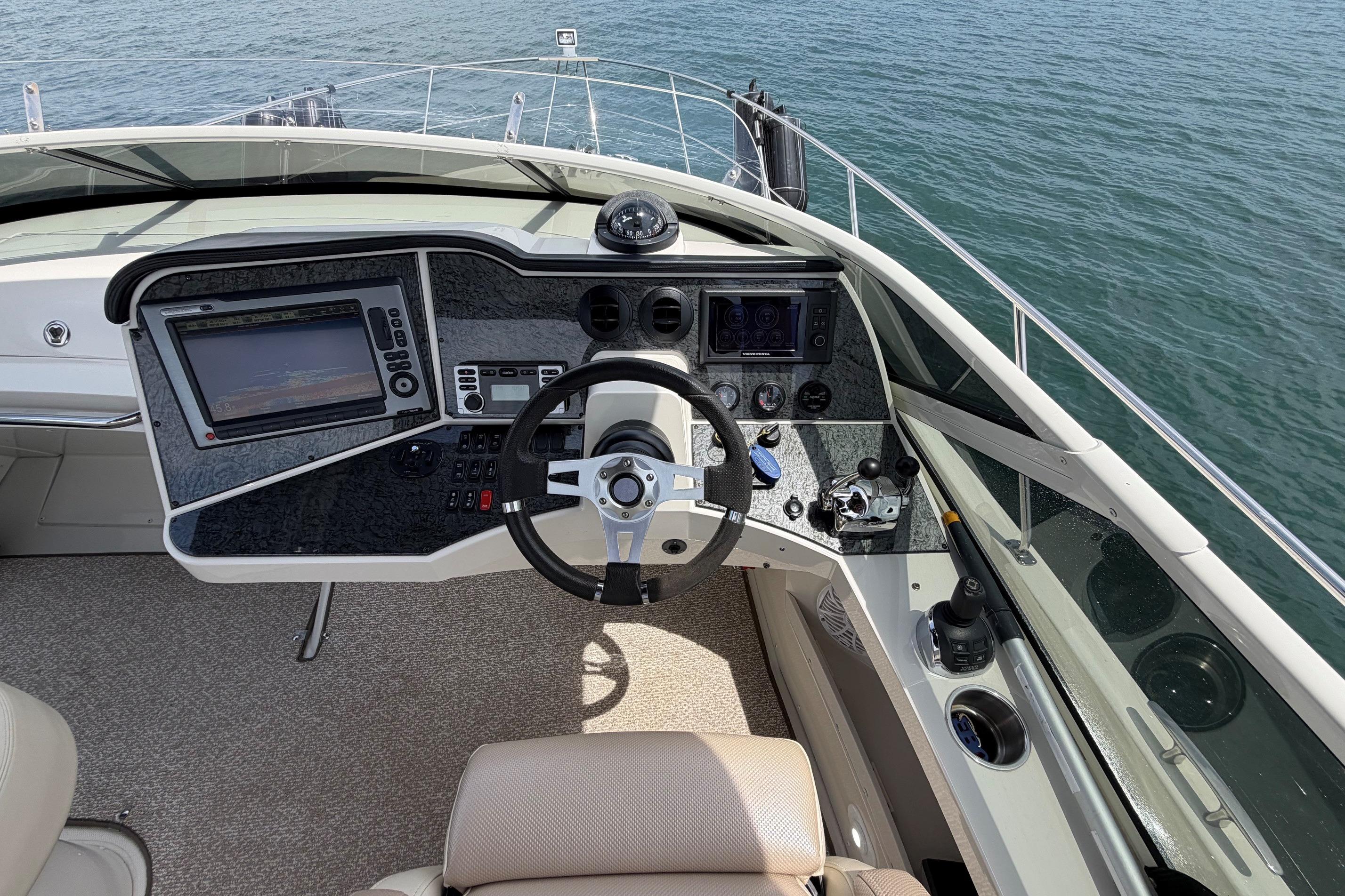 Helm of 2011 Carver 44 Sojourn yacht with navigation controls and ocean view.