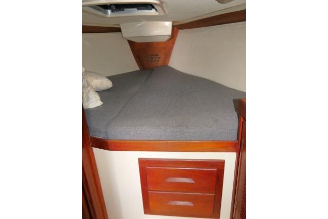 1995 Tartan 3100 boat cabin with bed and wooden drawers.
