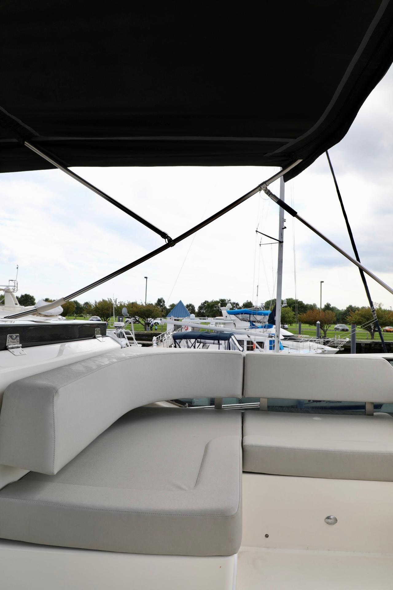 2019 Absolute 50 Fly yacht with cushioned seating, docked at marina.