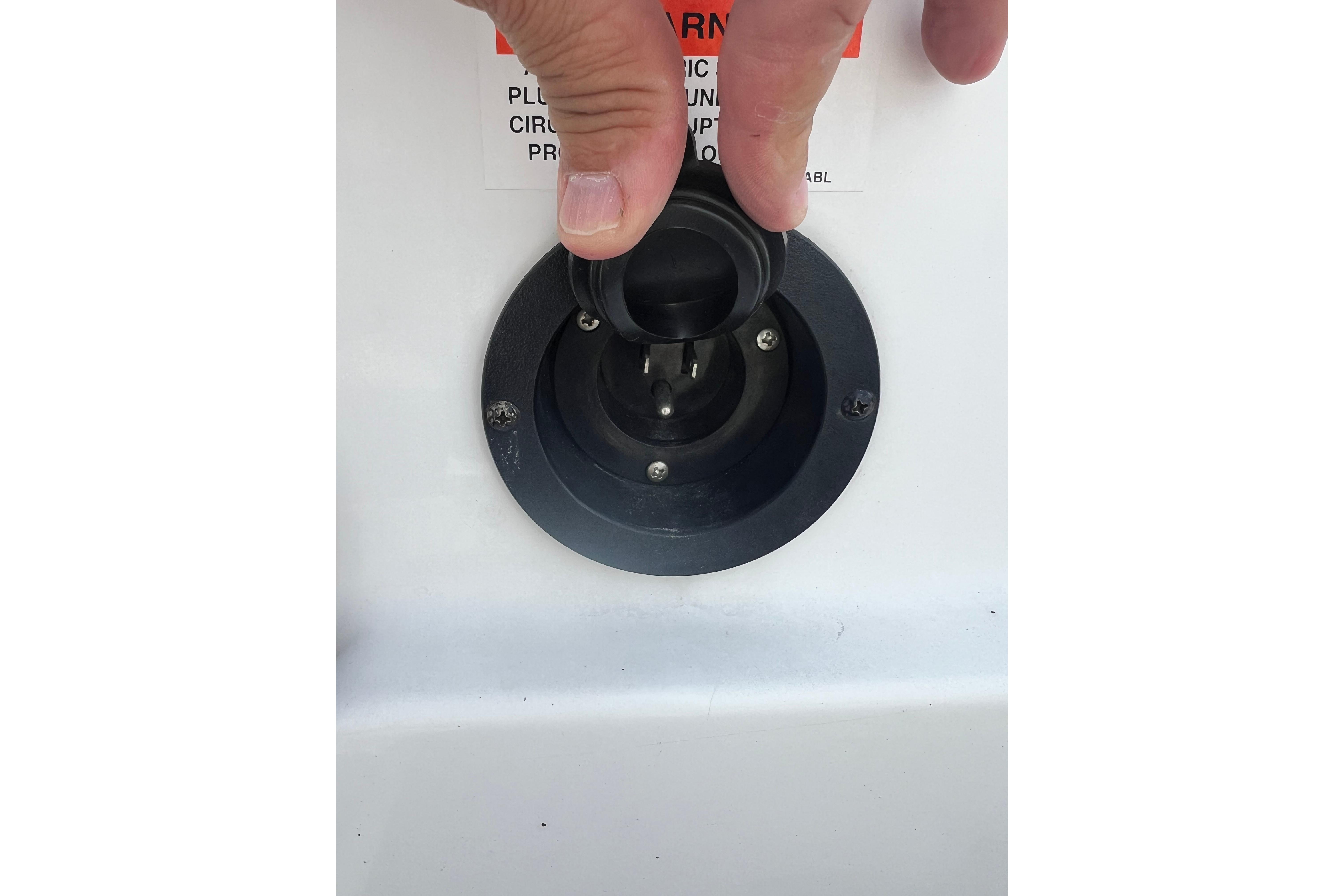 Close-up of a hand adjusting a plug on a 2015 Monterey 268SS Super Sport boat.