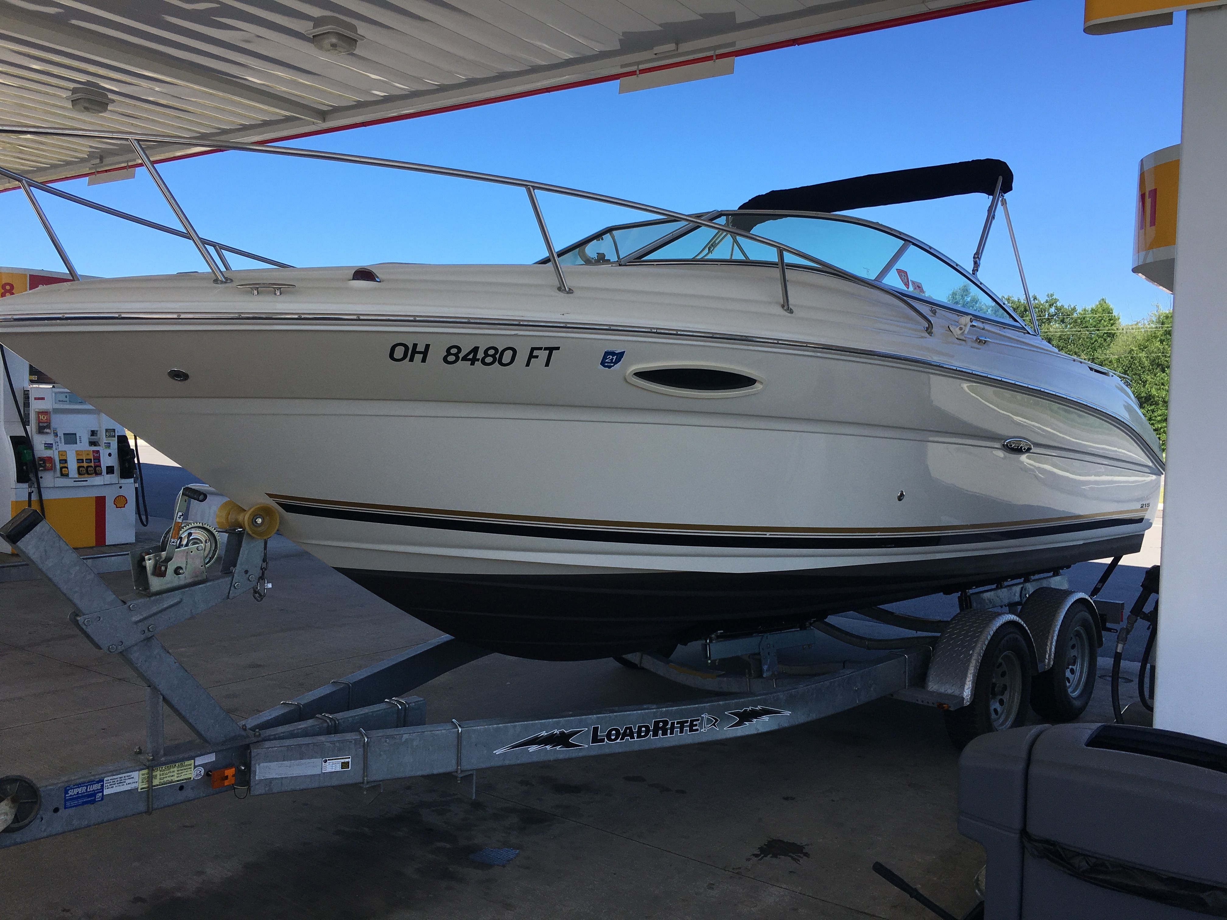 2006 Sea Ray 215 Weekender on trailer at gas station.