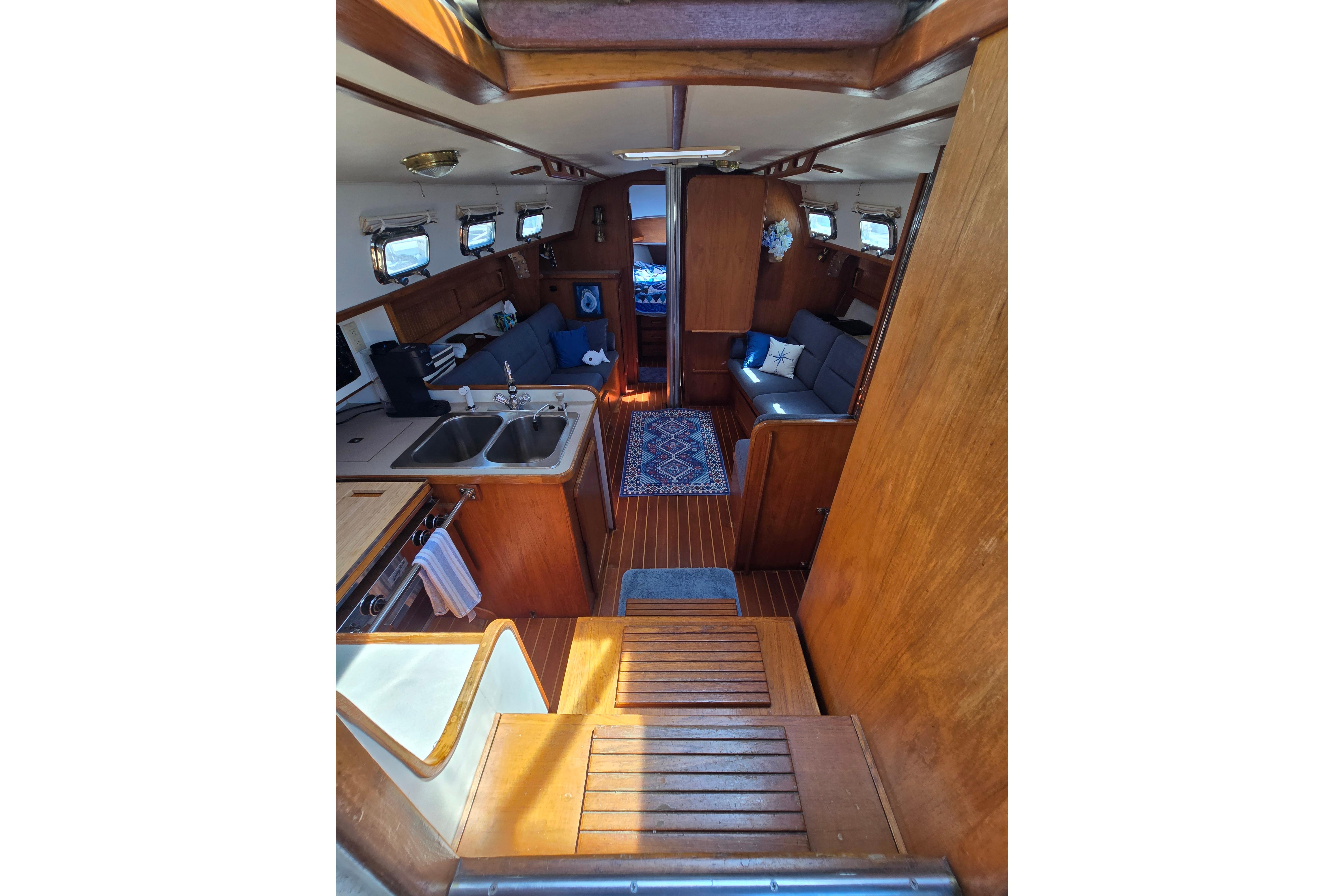 Interior of 1993 Caliber 35 sailboat with wooden finishes and cozy seating area.