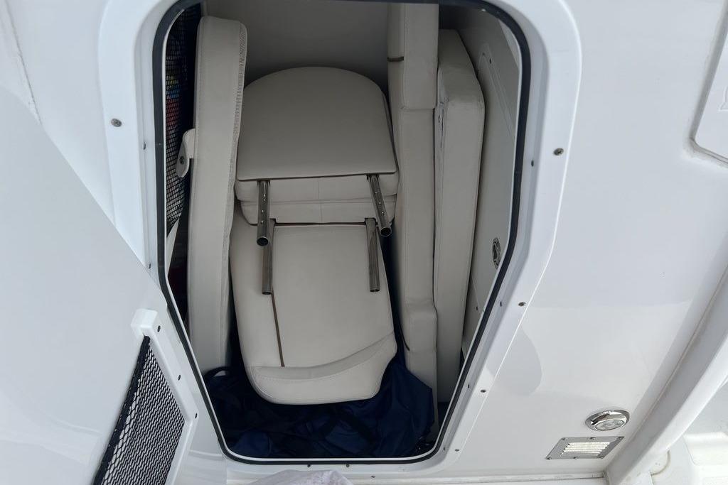 2021 Sea Hunt Gamefish 25 storage compartment with folded white seats.