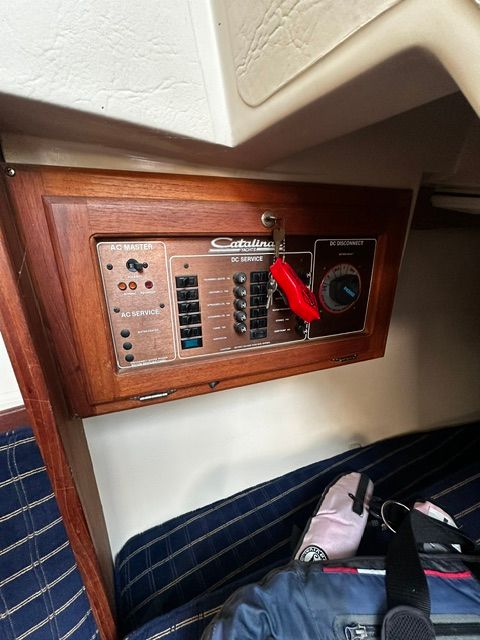 Electrical panel of a 1985 Catalina 27 with a wooden frame.