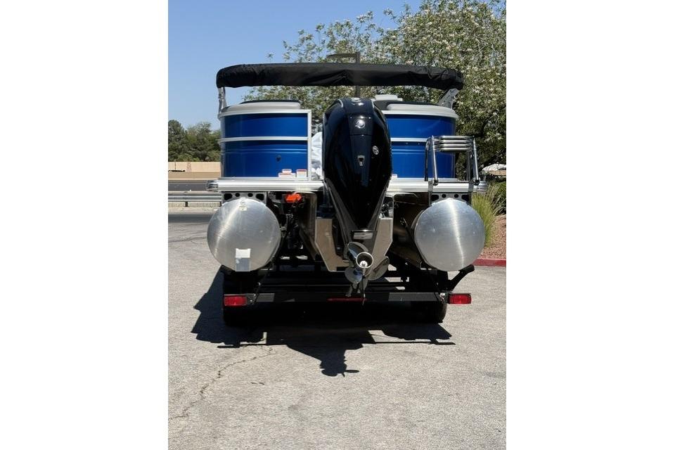 2026 Sun Tracker Party Barge 24 XP3 pontoon boat, rear view with motor and trailer.
