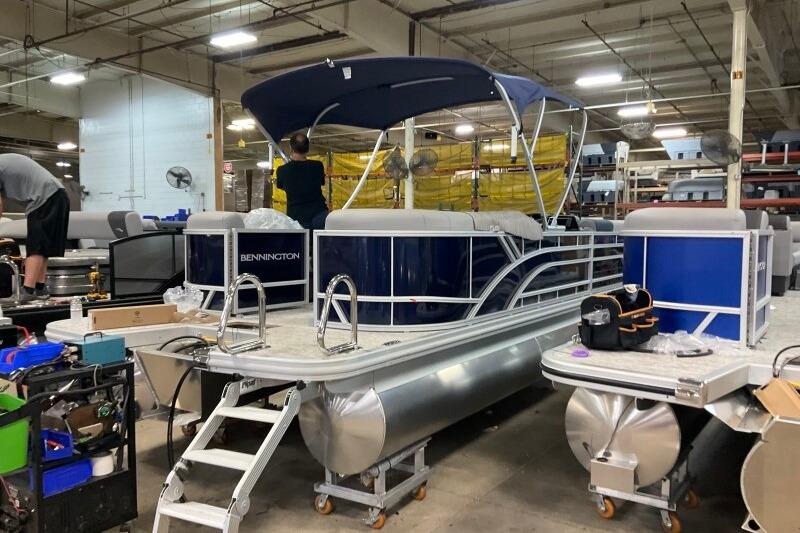 2026 Bennington 23 SSRSF pontoon boat in a factory setting, under assembly.