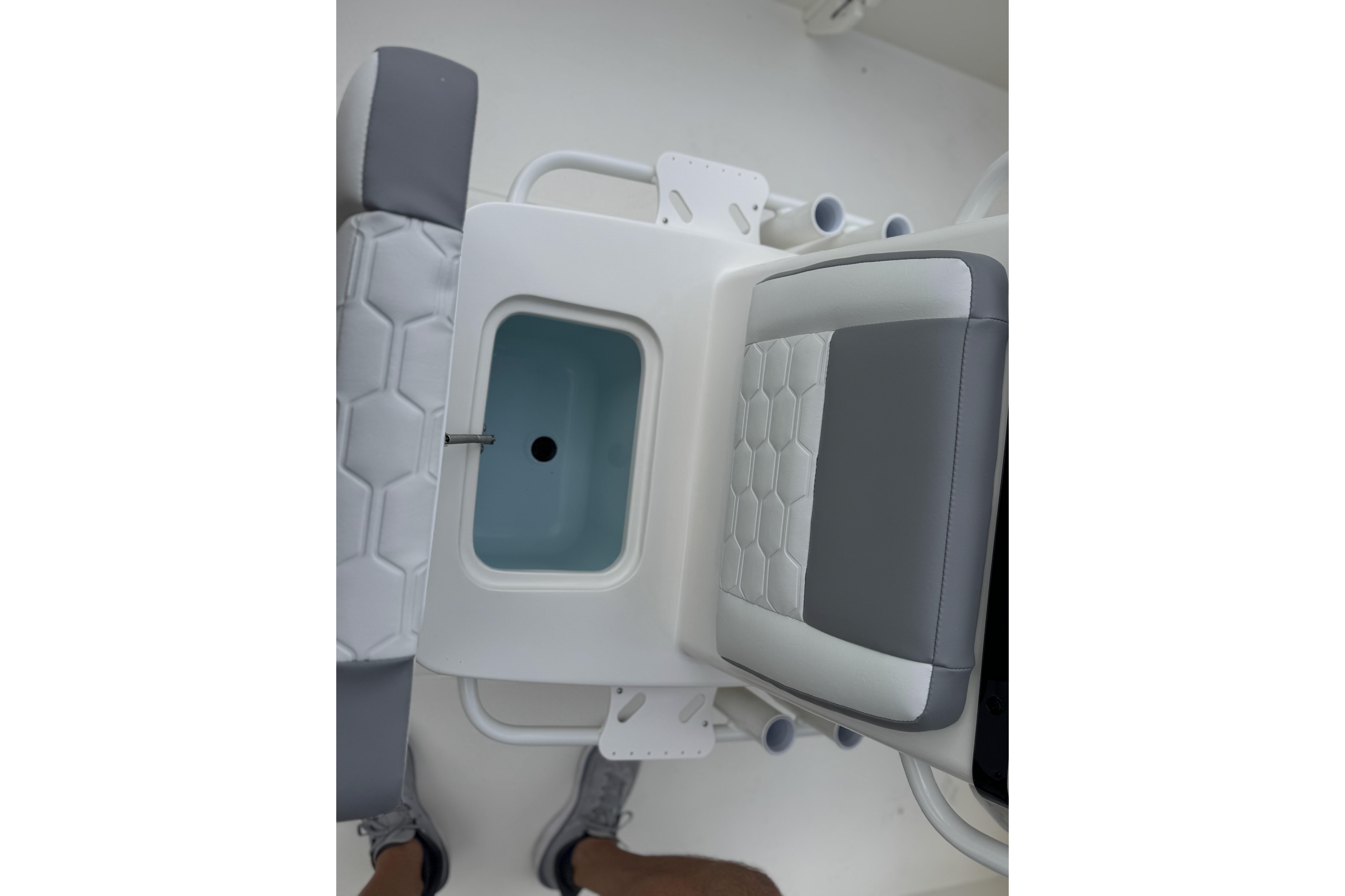 2026 Mako 18 Pro Skiff interior with cushioned seating and storage compartment.