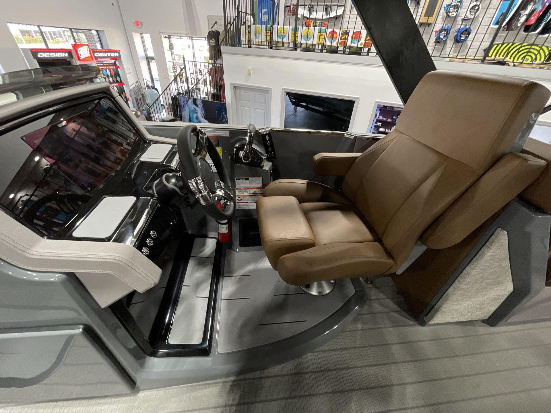 Captain's seat and helm of 2025 Balise Horizon 26C boat, featuring modern controls and design.