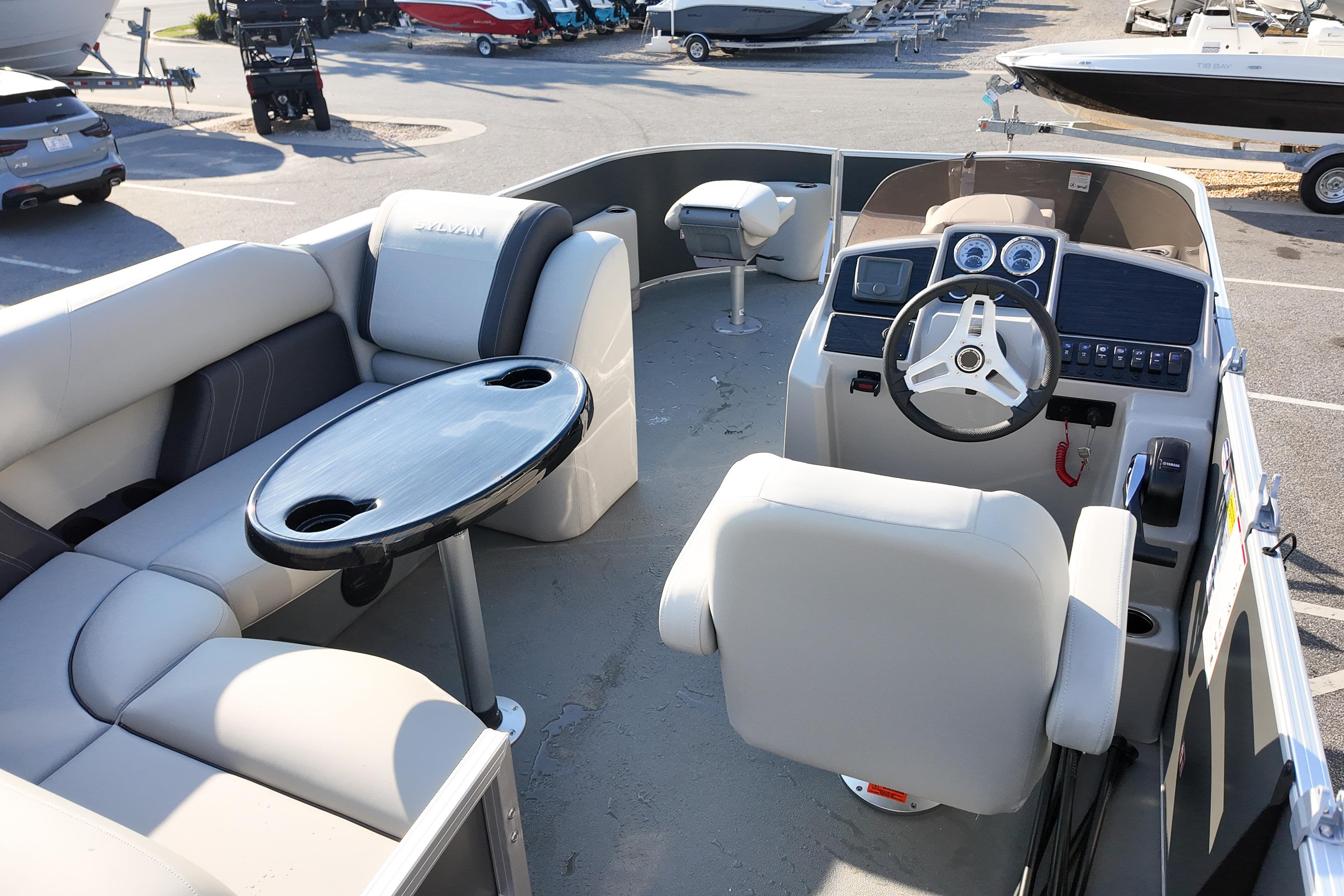 2026 Sylvan Mirage 818 Fish boat interior with seating, table, and steering console.